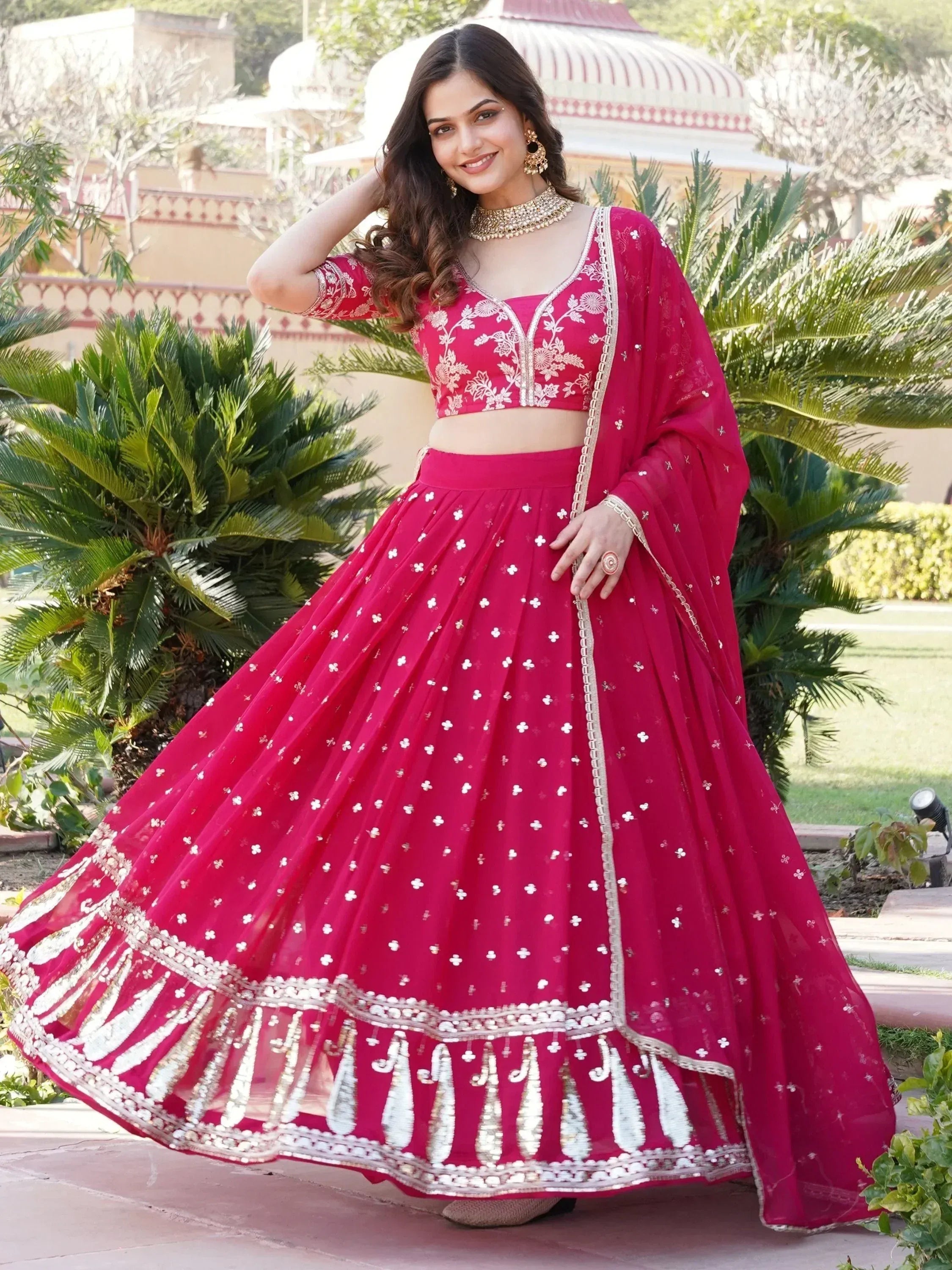Pink embroidered lehenga choli with floral motifs and gold detailing, perfect for Indian weddings and festive occasions.