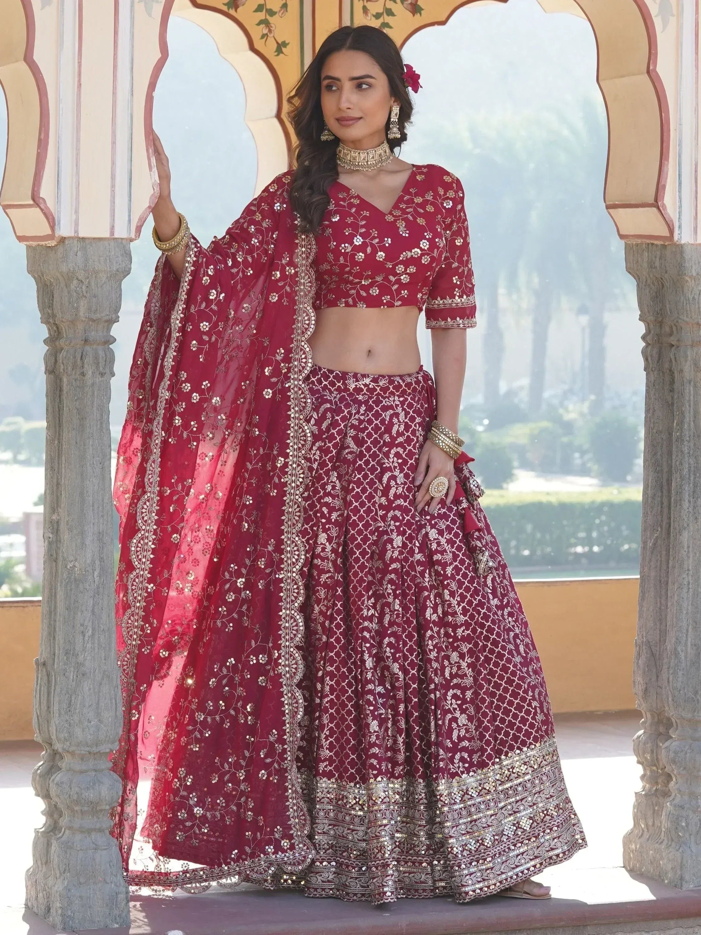 Maroon embroidered lehenga choli with gold detailing, perfect for Indian weddings and festive occasions.