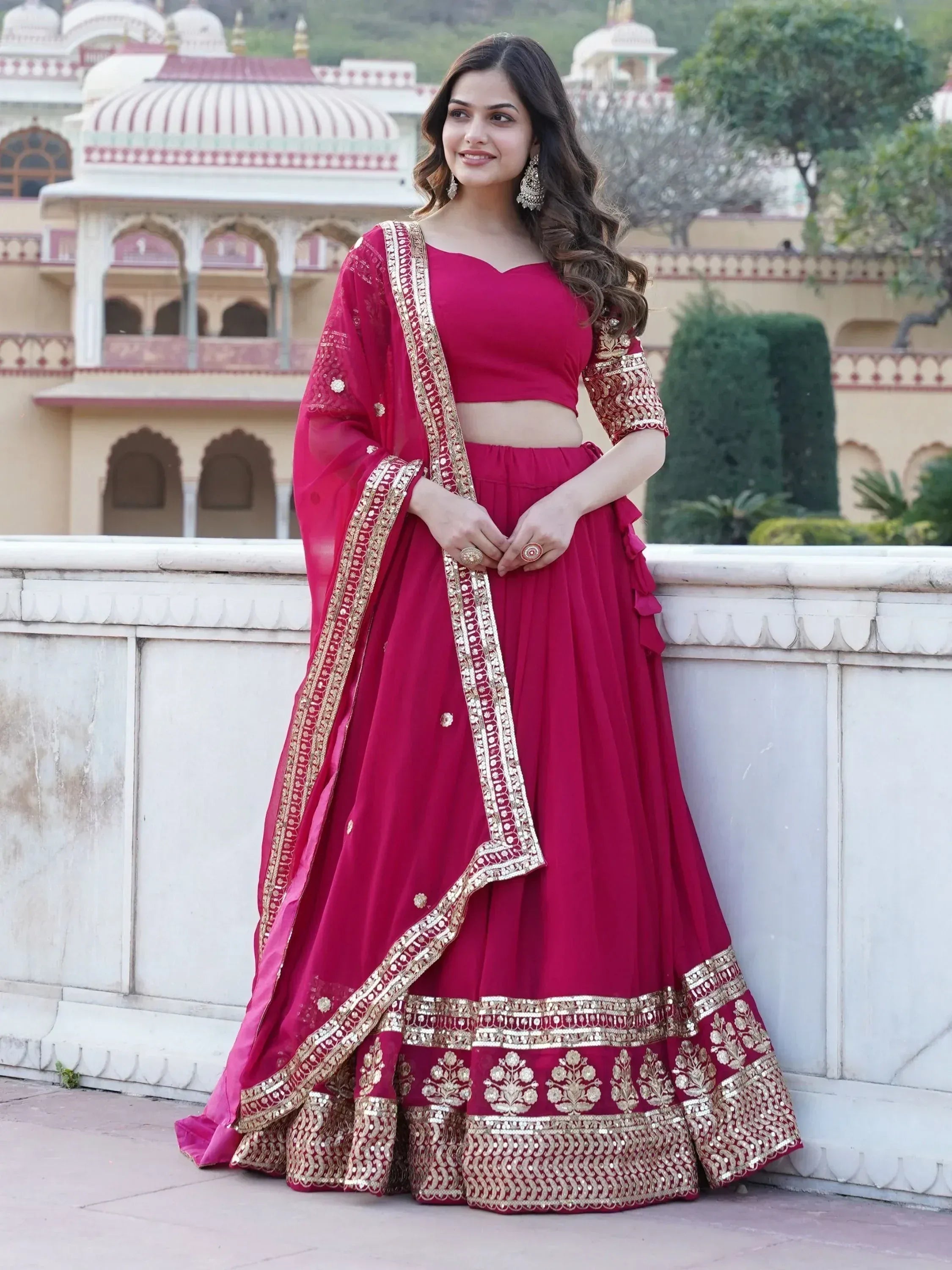 Woman in maroon designer lehenga choli with gold embroidery, perfect for Indian ethnic wear occasions