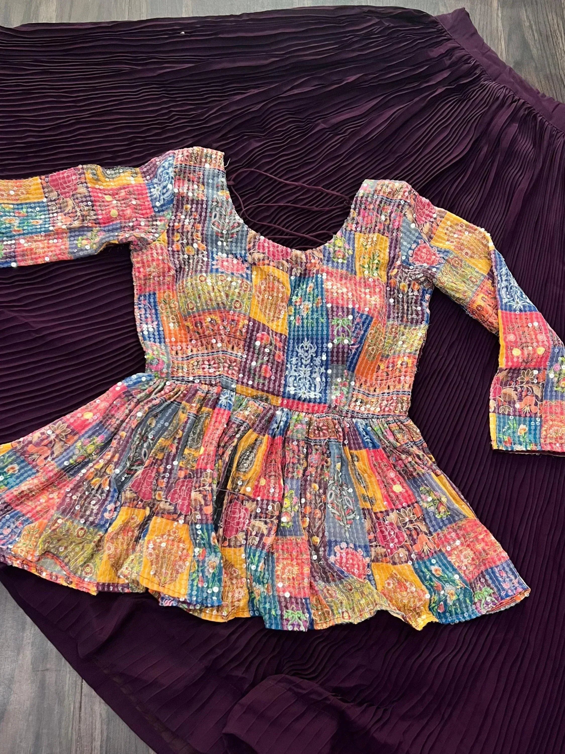 Colorful patchwork ethnic top with sequins paired with pleated purple skirt, perfect for Indian festive wear.