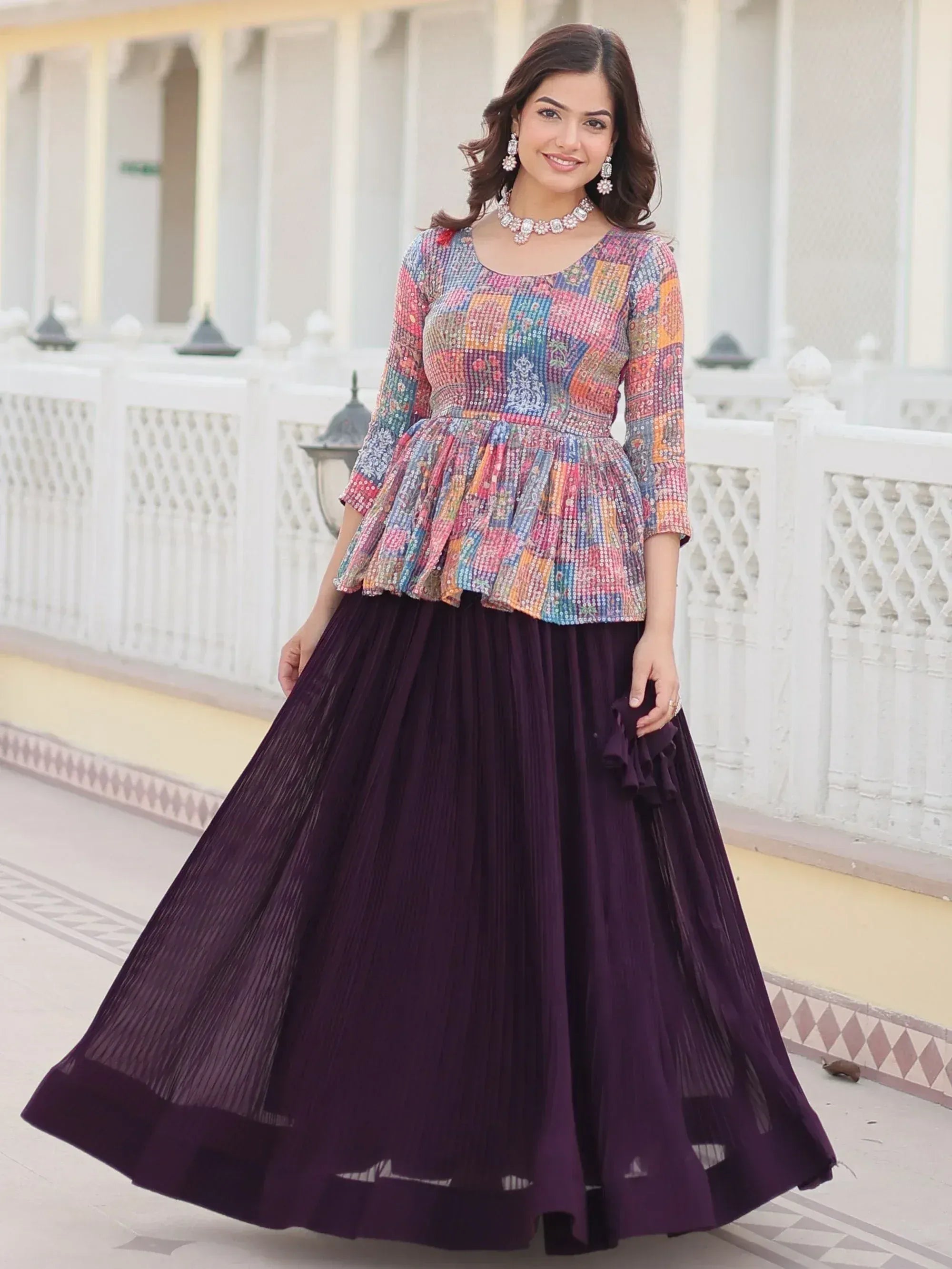 Woman in colorful sequin peplum top with purple pleated skirt, Indian ethnic wear