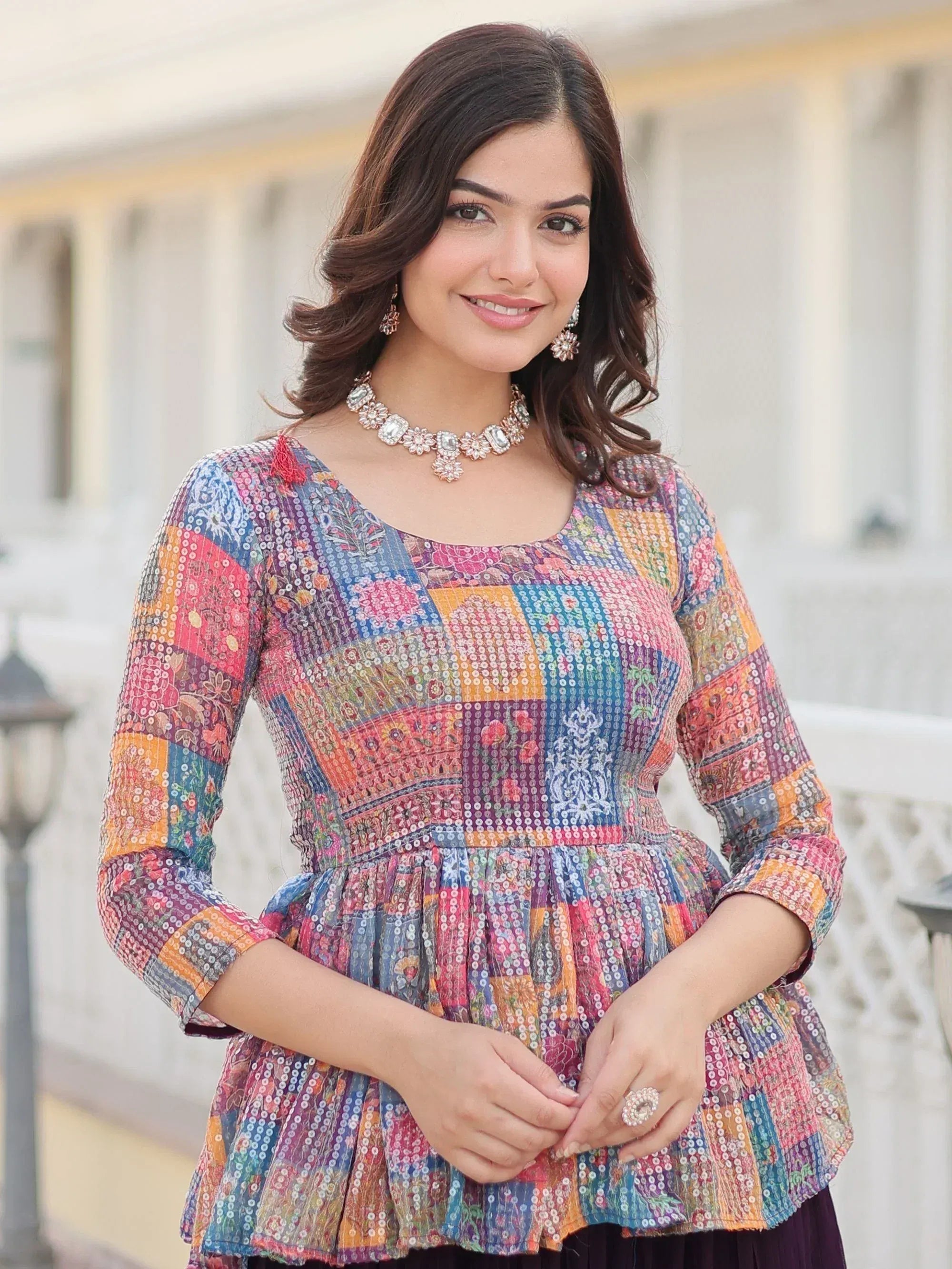 Colorful patchwork ethnic top with sequins, floral prints, and peplum hem for women