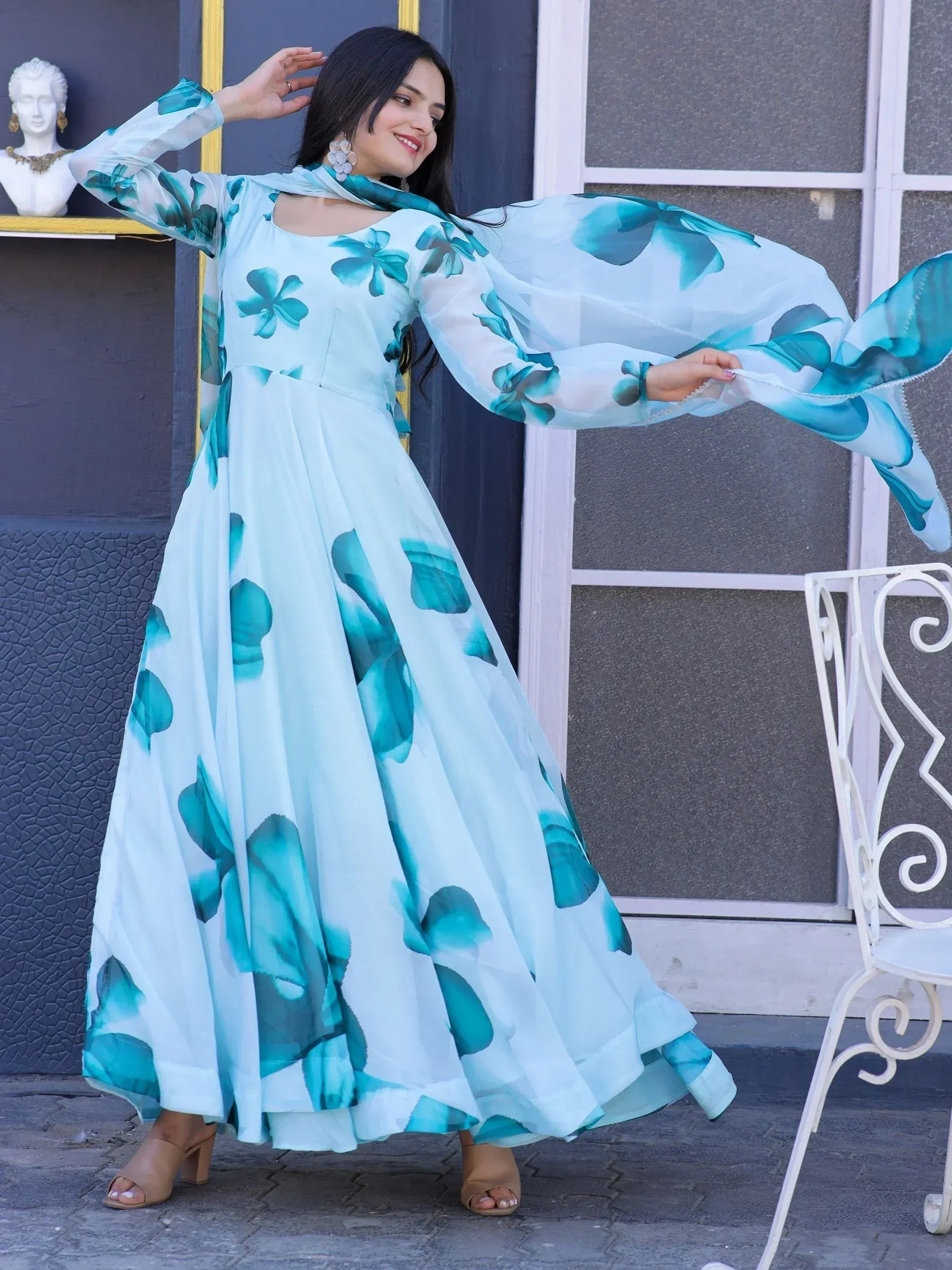 Woman in elegant floral print ethnic gown with flowing sleeves, perfect for Indian occasions