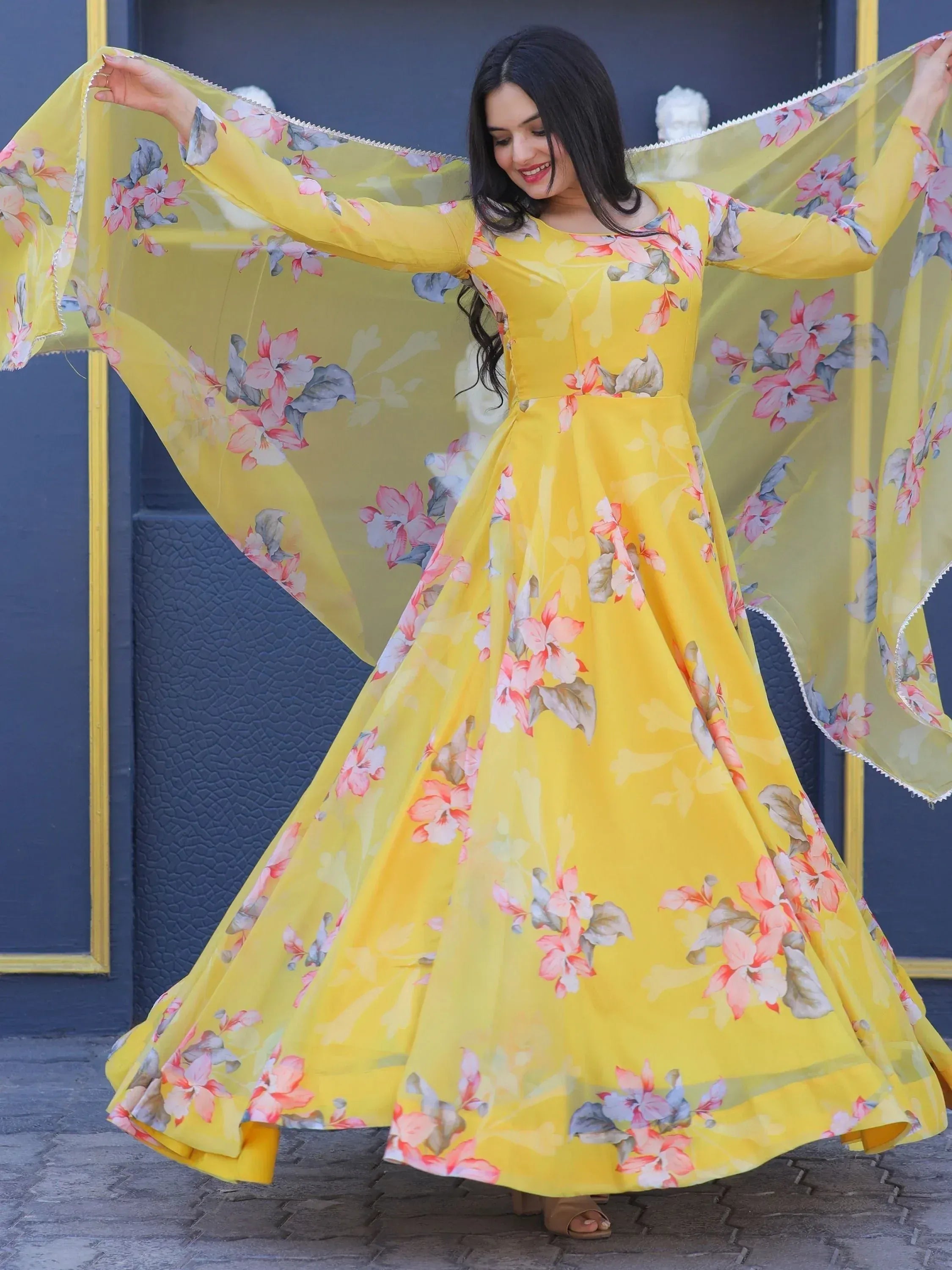 Yellow floral ethnic gown with flowing sleeves, perfect for Indian occasions and festive wear.