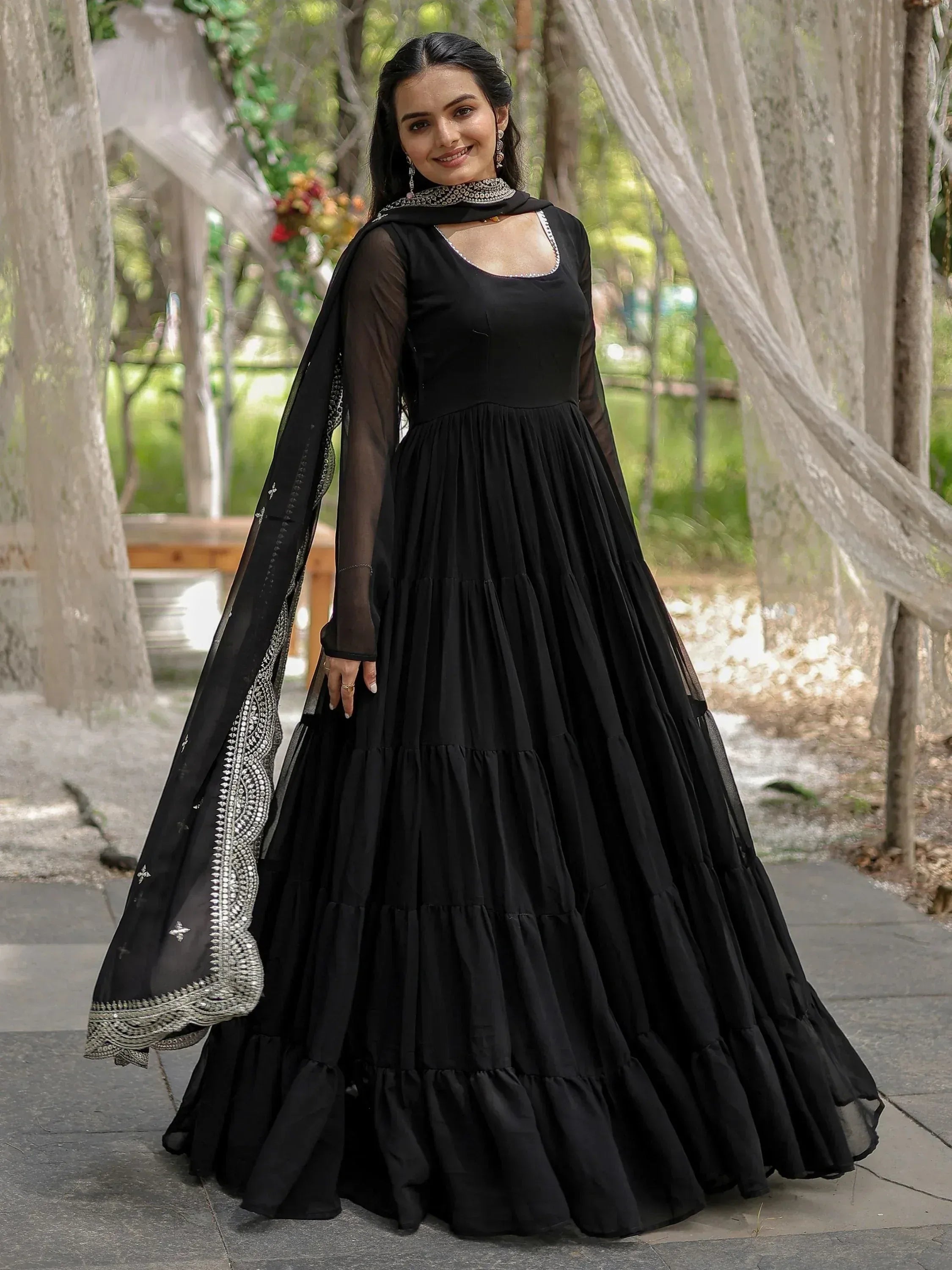 Black tiered ethnic gown with sheer sleeves and embellished dupatta for Indian wear