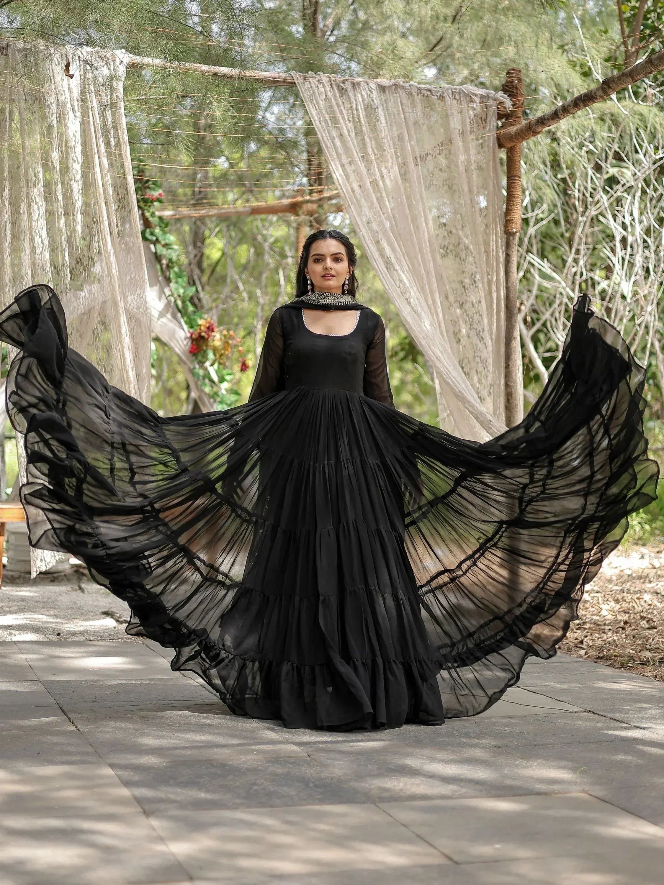 Black ethnic gown with flowing layered skirt, sheer sleeves, and embellished neckline for festive occasions