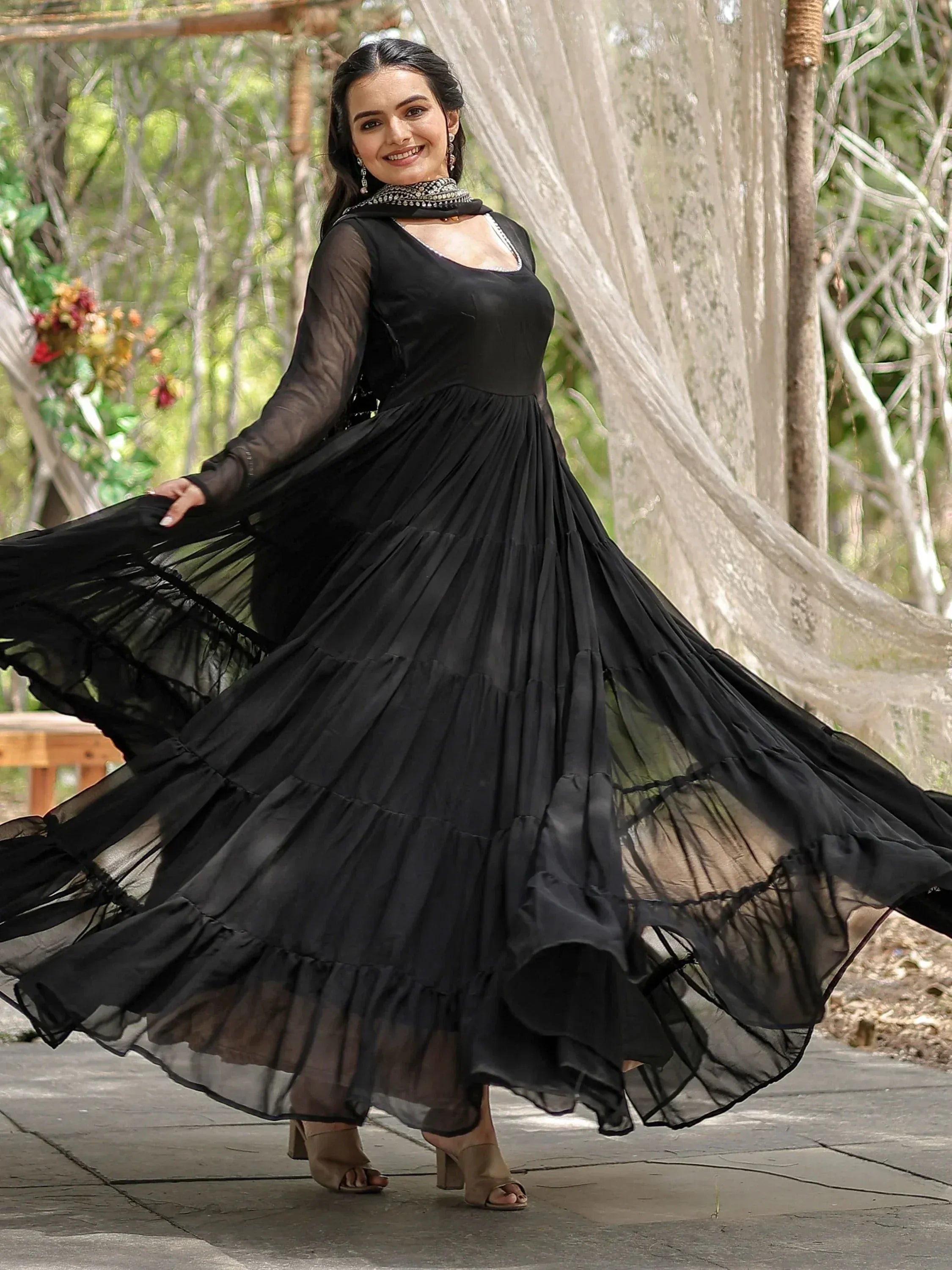 Black ethnic gown with sheer sleeves and tiered skirt, perfect for Indian festive occasions