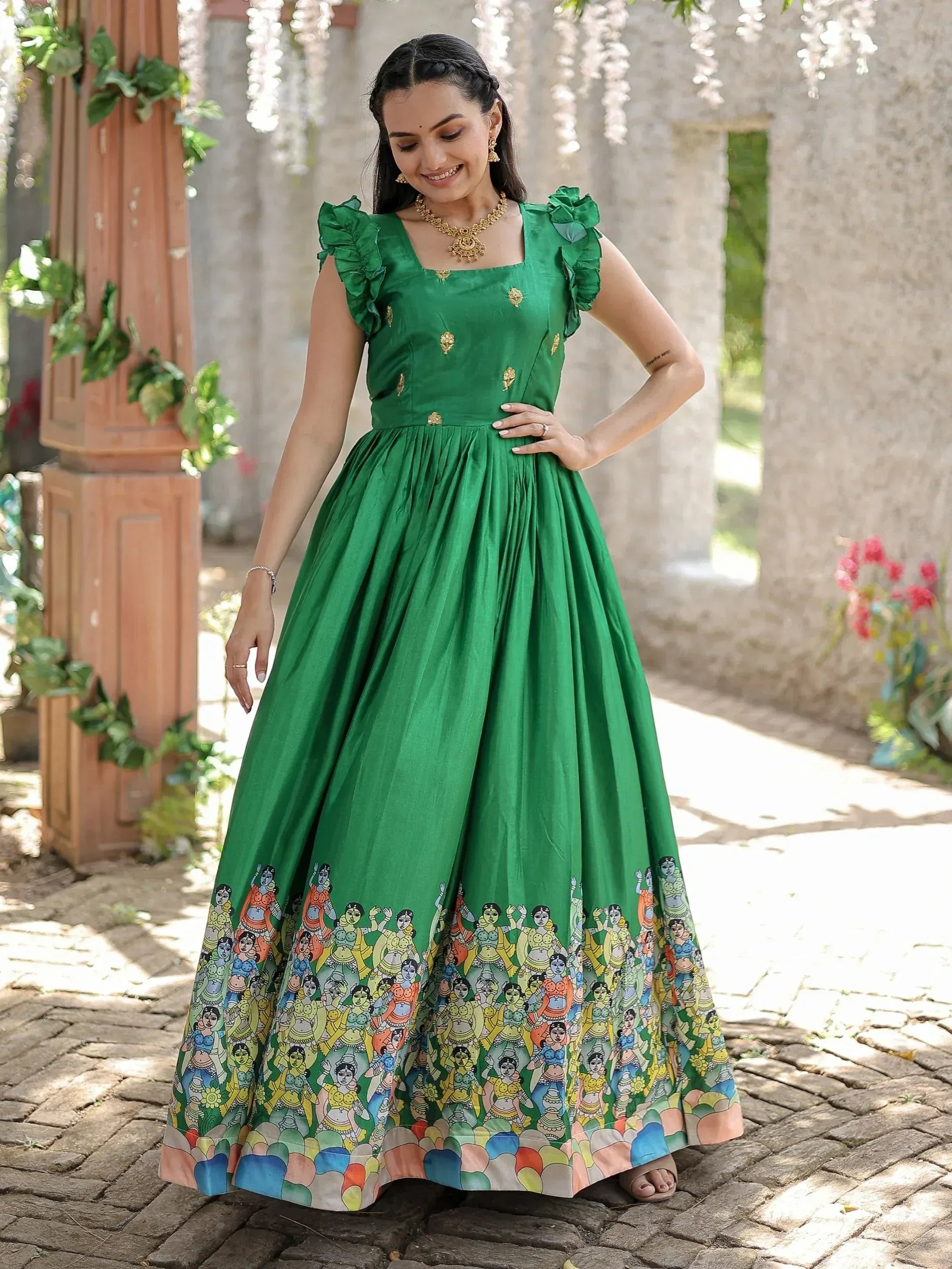 Green ethnic gown with ruffle sleeves and colorful folk art print, perfect for Indian occasions.