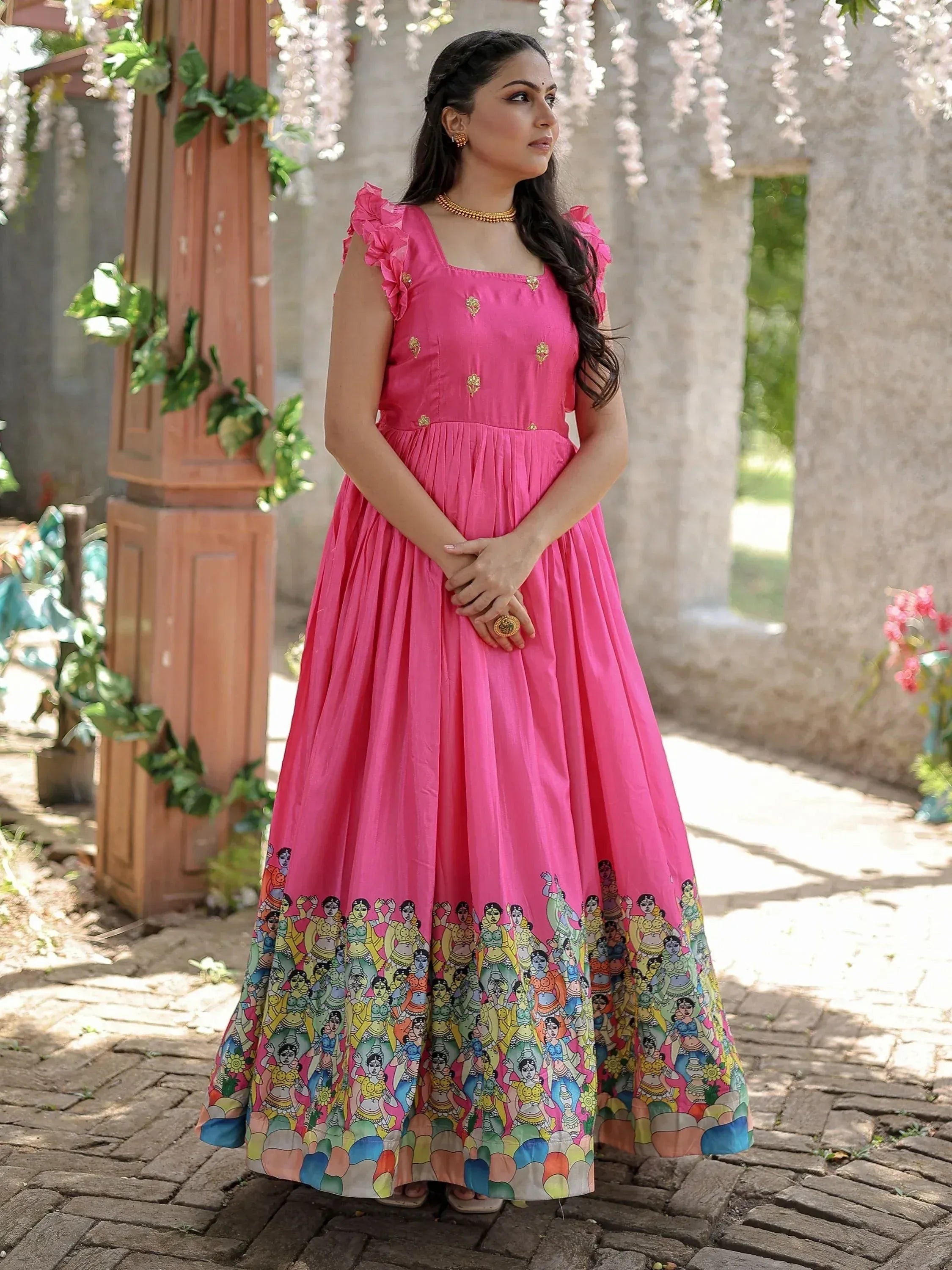Pink ethnic gown with ruffle sleeves and colorful folk art print, perfect for Indian occasions