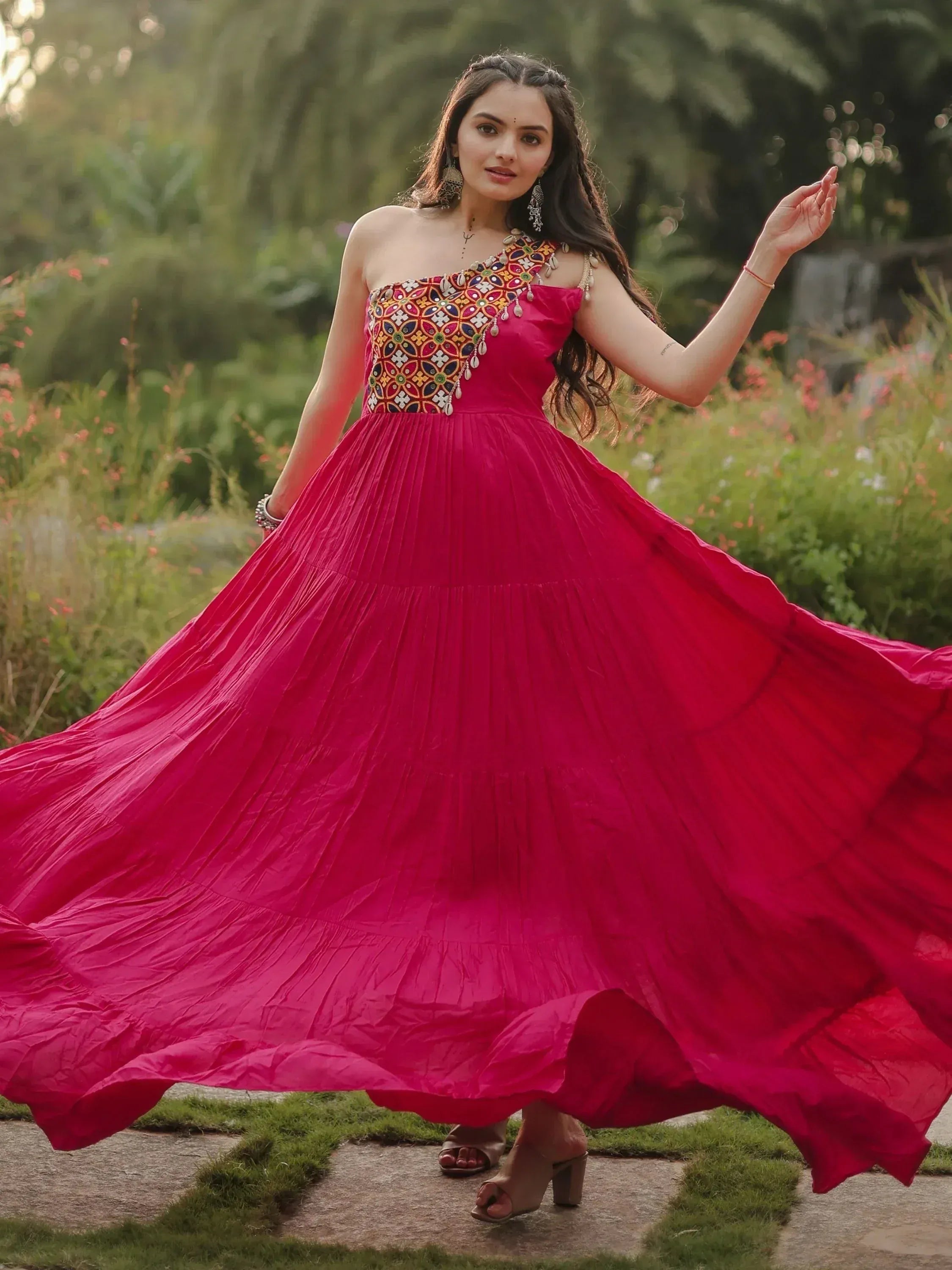 Vibrant pink ethnic gown with colorful embroidery, perfect for Indian occasions and festive wear.