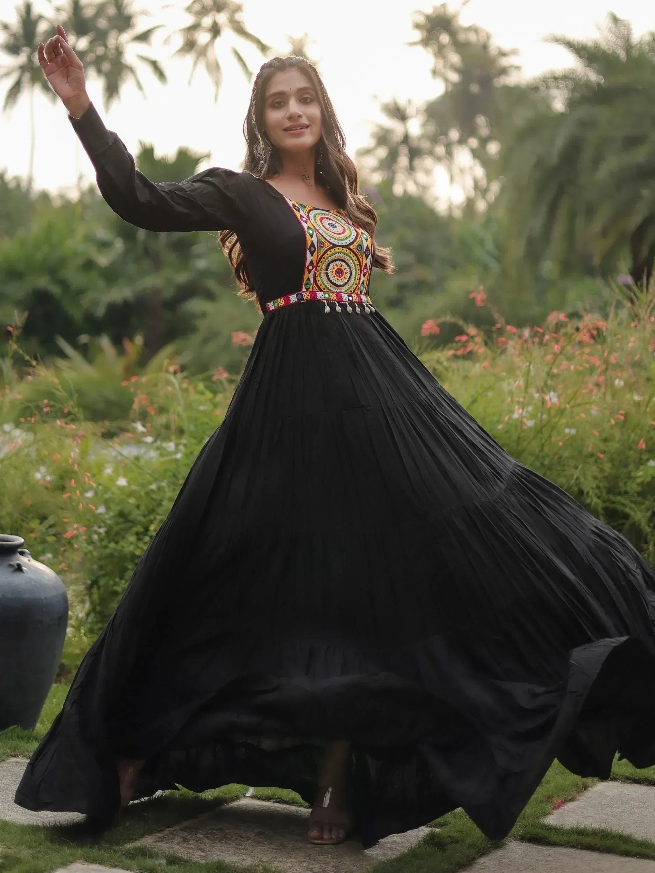 Black ethnic gown with colorful embroidery, pleated skirt, worn in garden setting