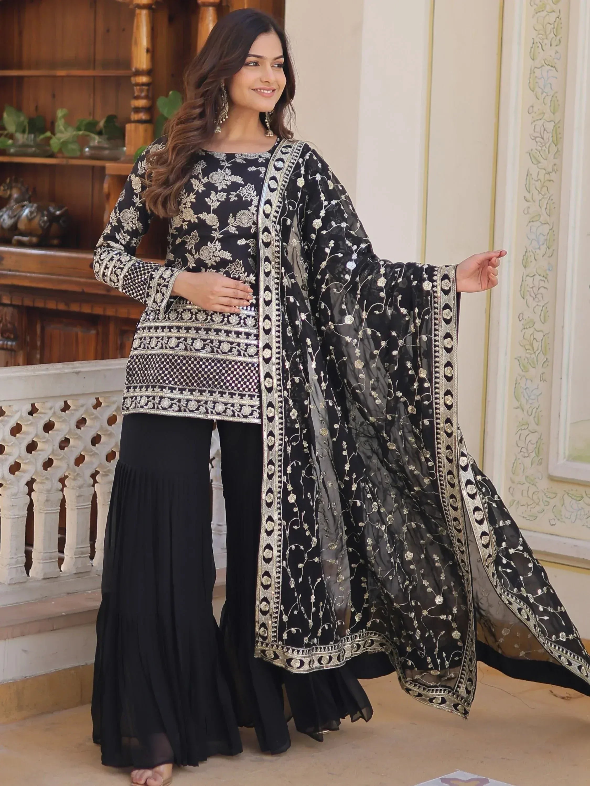 Black embroidered salwar kameez with gold floral work, flared pants, and sheer dupatta for Indian ethnic wear
