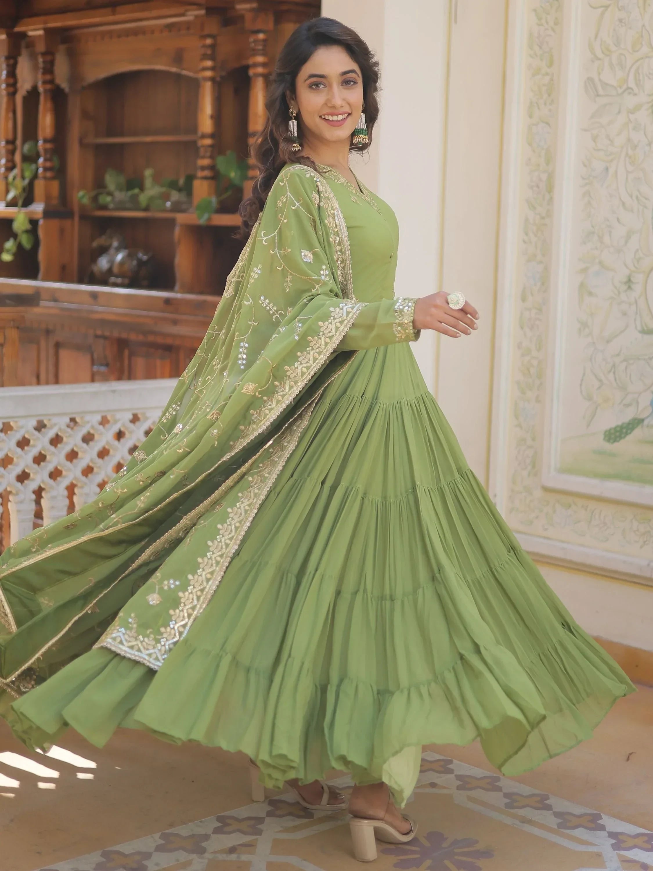 Woman in green Anarkali dress with gold embroidered dupatta, ethnic Indian attire