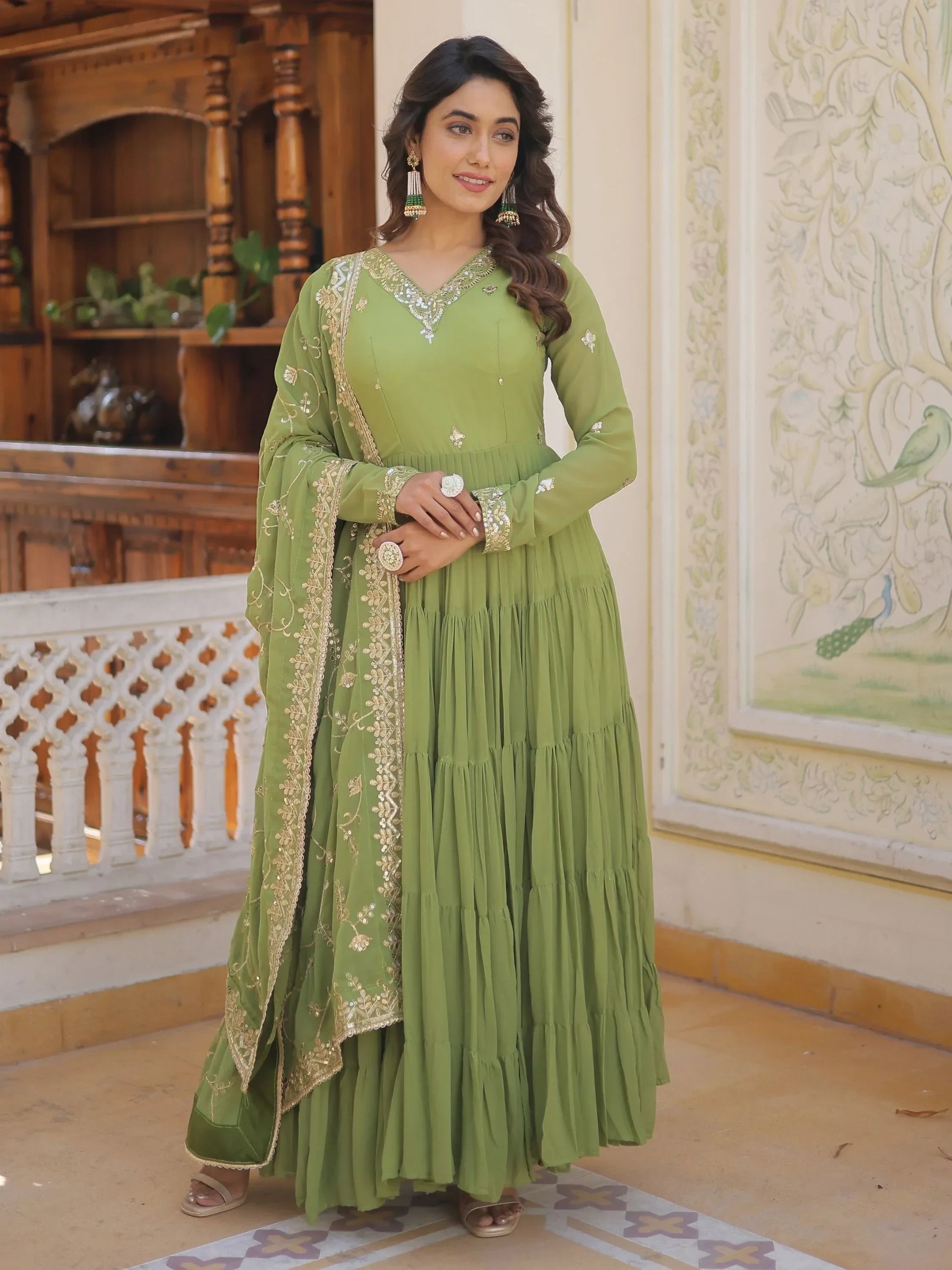 Woman in green embroidered Anarkali suit with matching dupatta, traditional Indian ethnic wear