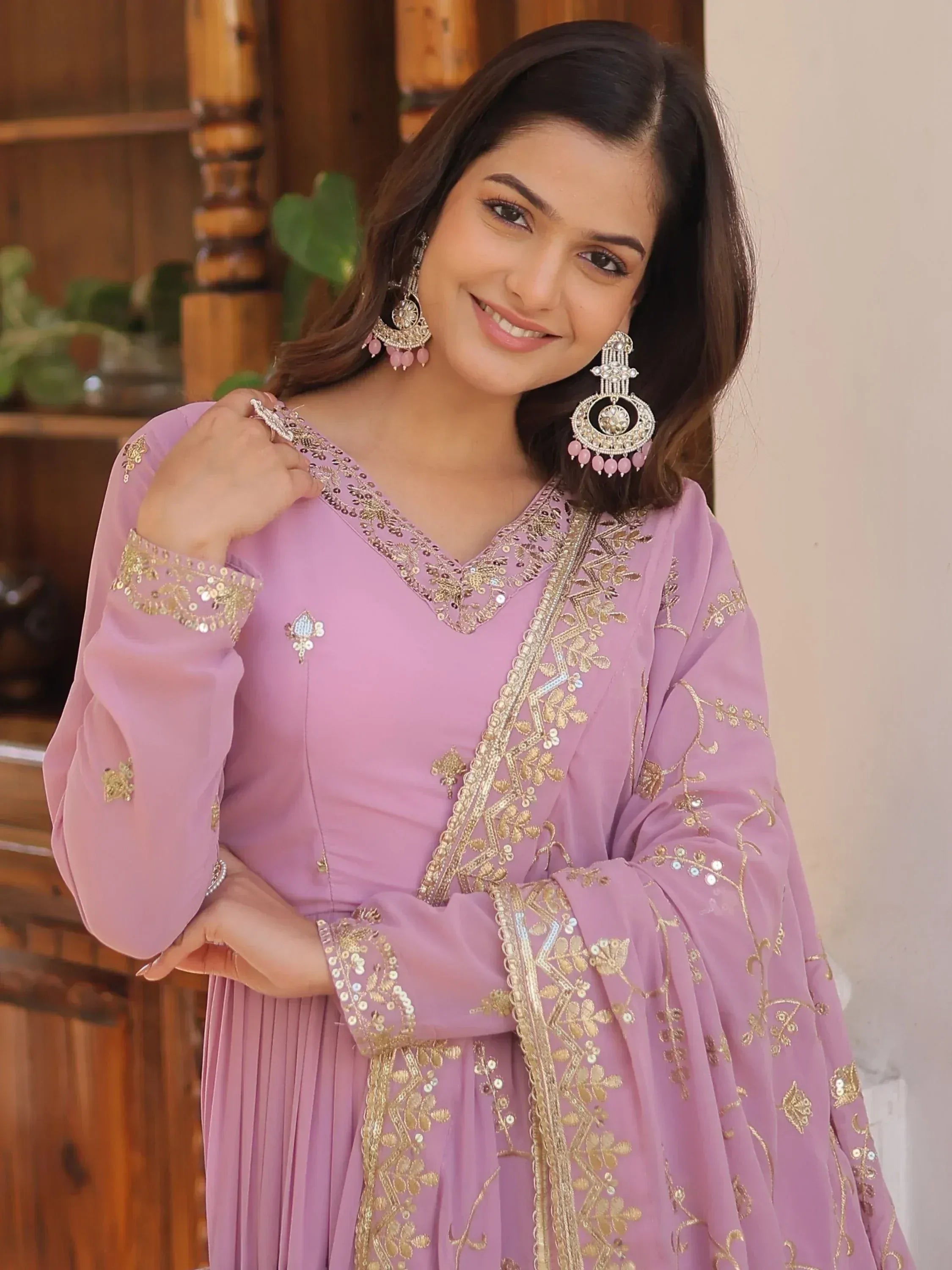 Pink embroidered ethnic gown with gold detailing and matching jhumka earrings
