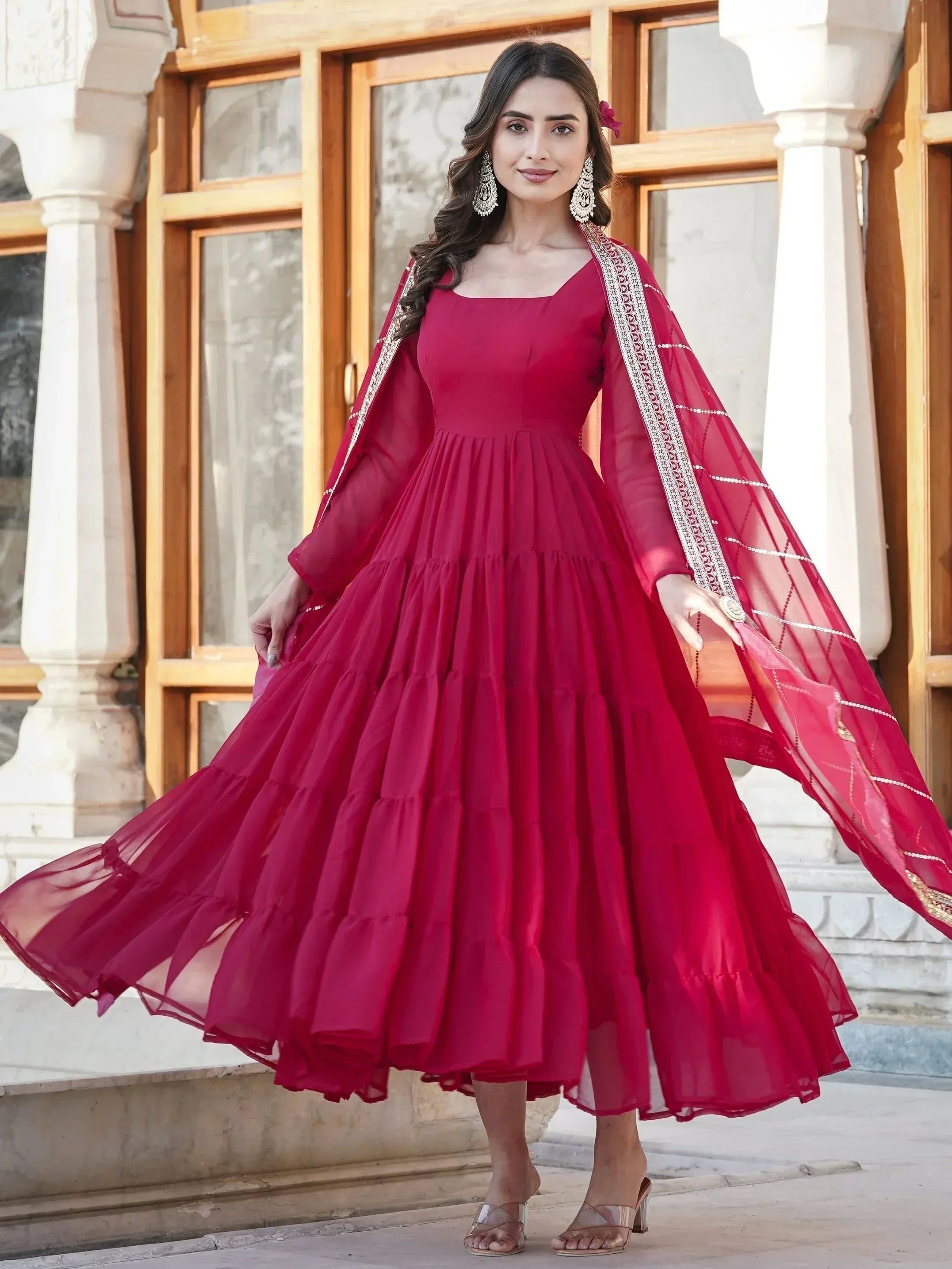 Red ethnic gown with tiered skirt and embroidered dupatta, perfect for Indian occasions