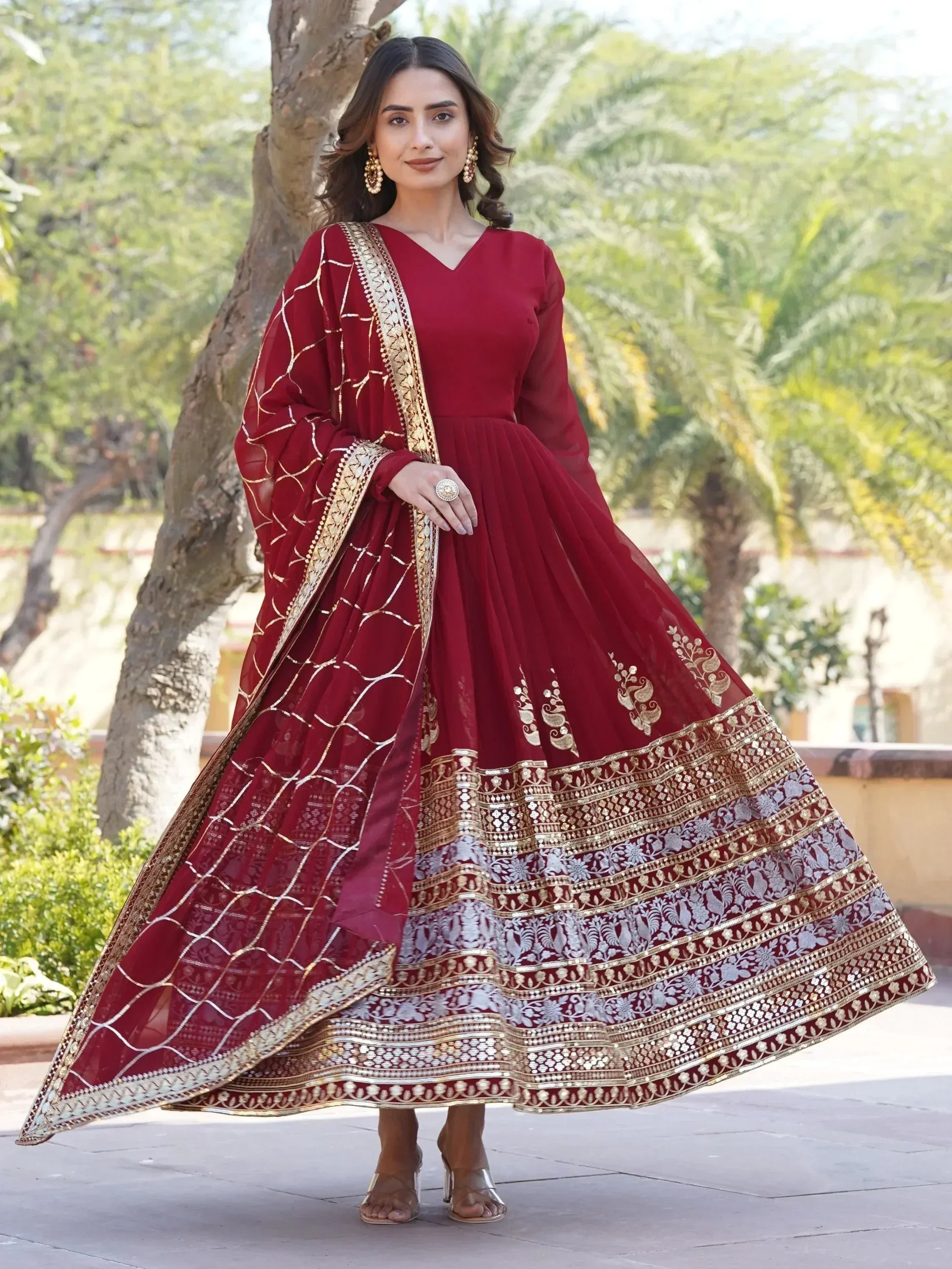 Maroon ethnic gown with gold embroidery and dupatta, perfect for Indian weddings and festive occasions