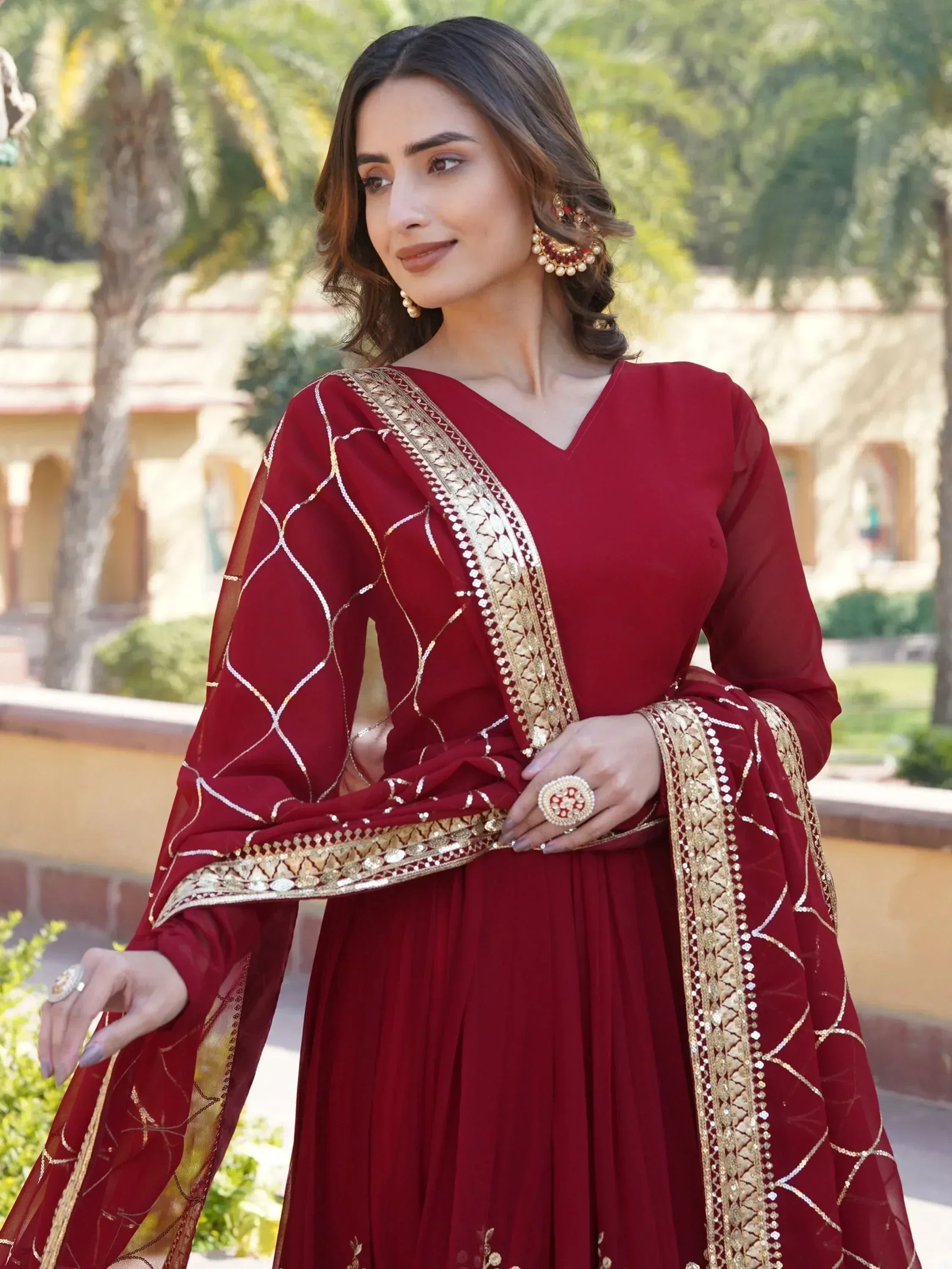 Maroon ethnic gown with gold embroidery, perfect for Indian weddings and festive occasions.