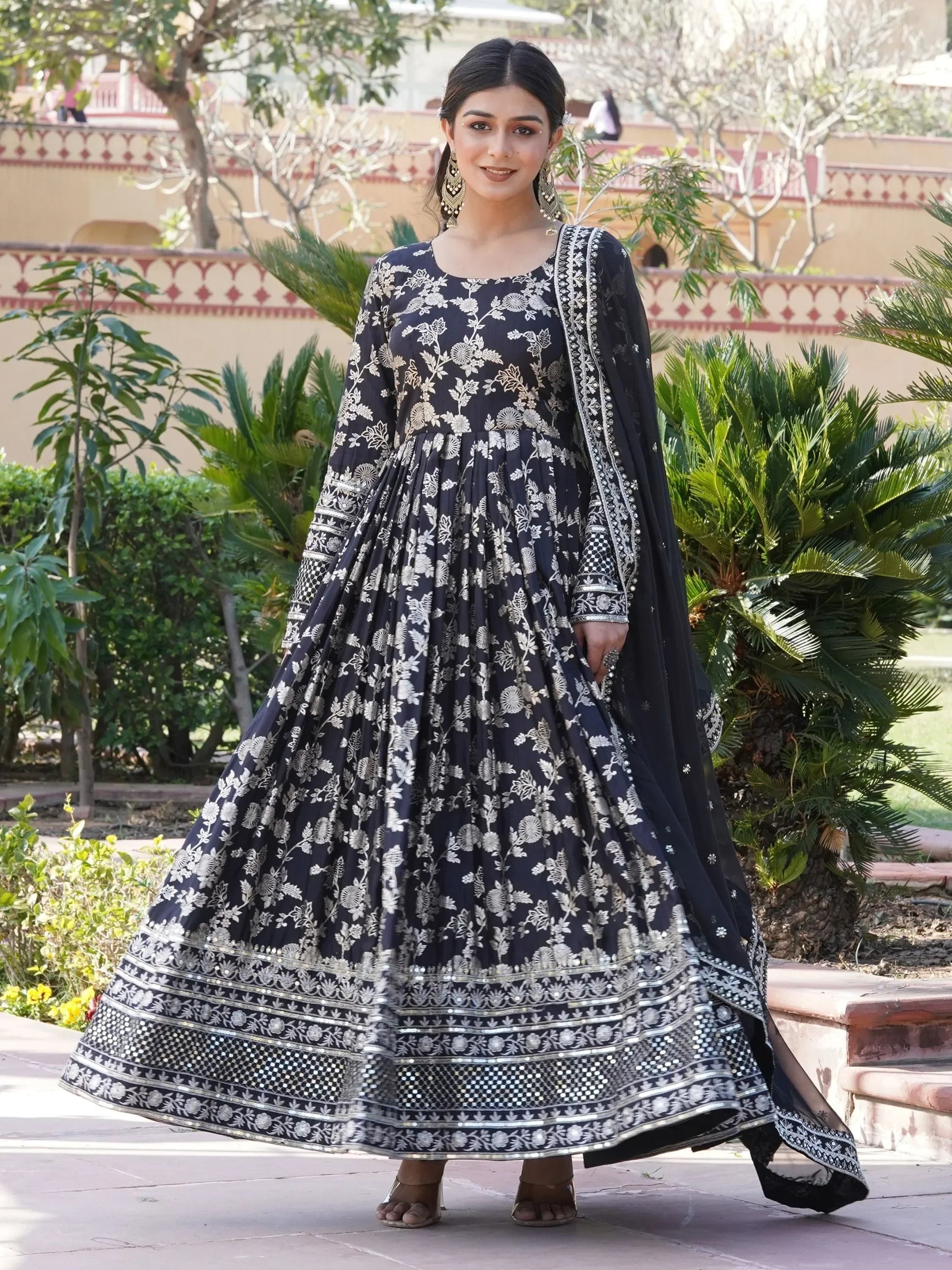 Woman wearing a black and silver floral embroidered Anarkali gown with dupatta outdoors