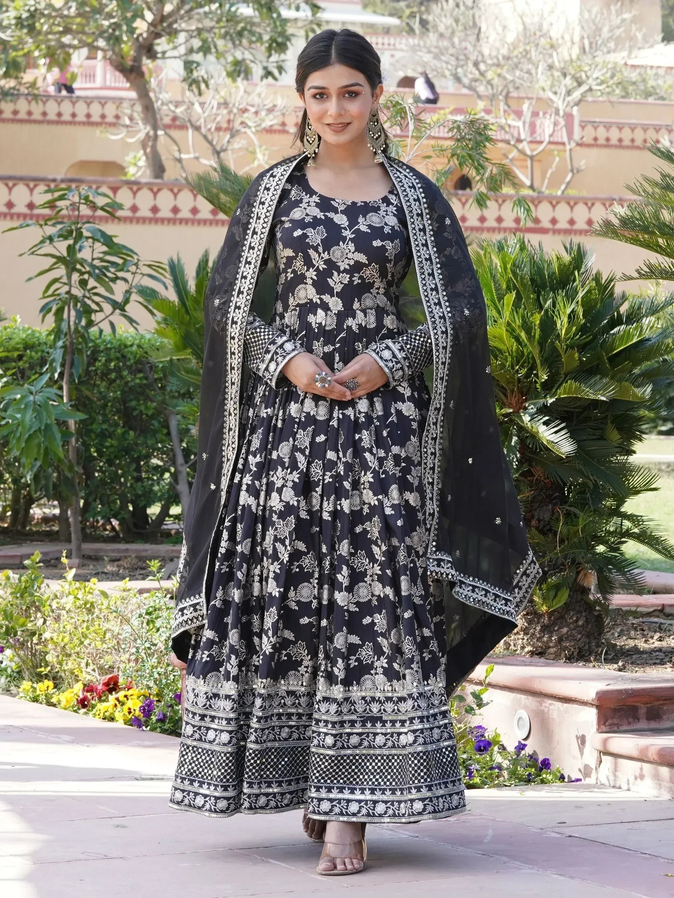 Woman in black and silver floral embroidered ethnic gown with dupatta outdoors
