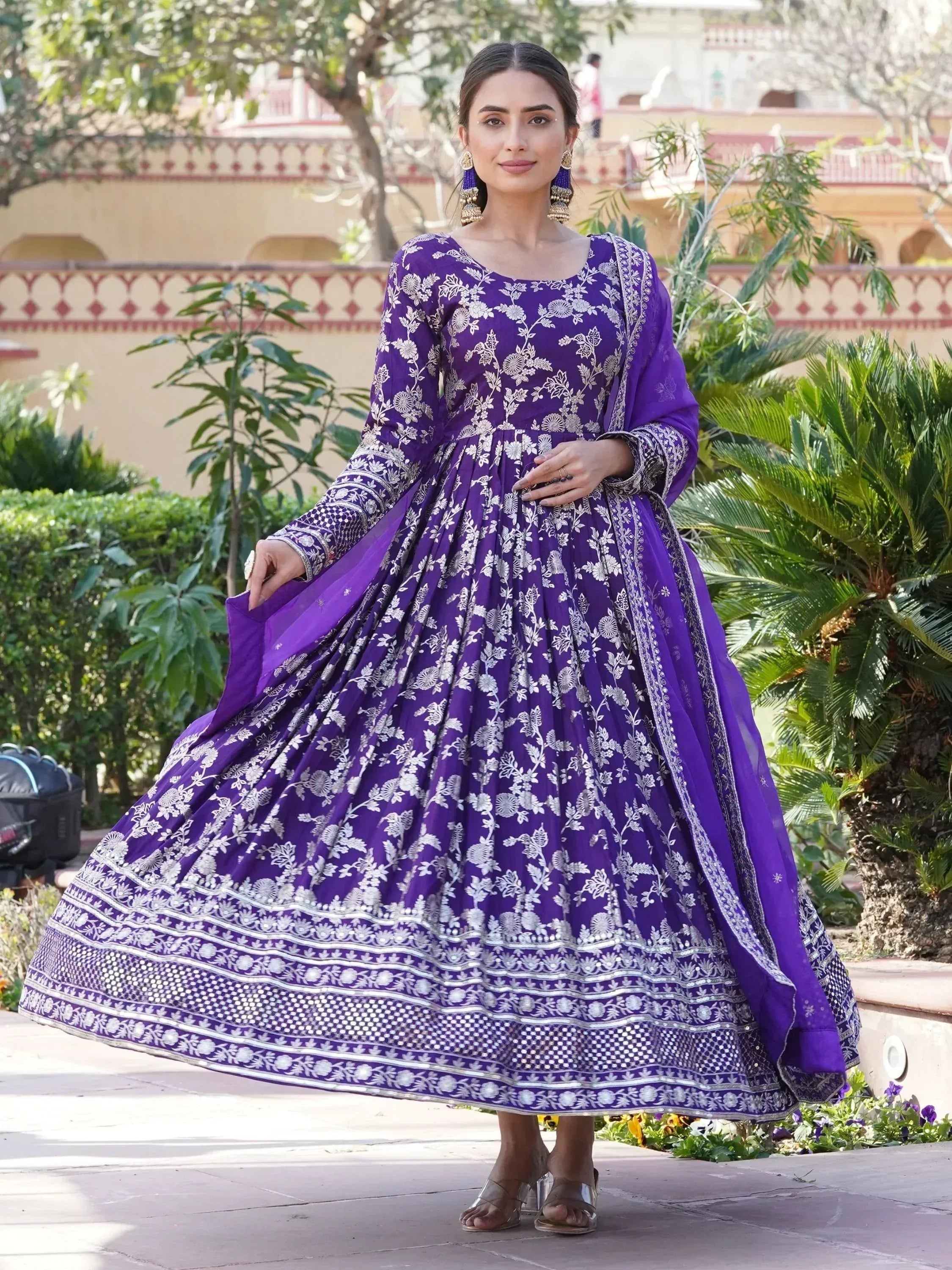 Woman wearing a purple embroidered Anarkali gown with dupatta, Indian ethnic wear outdoors