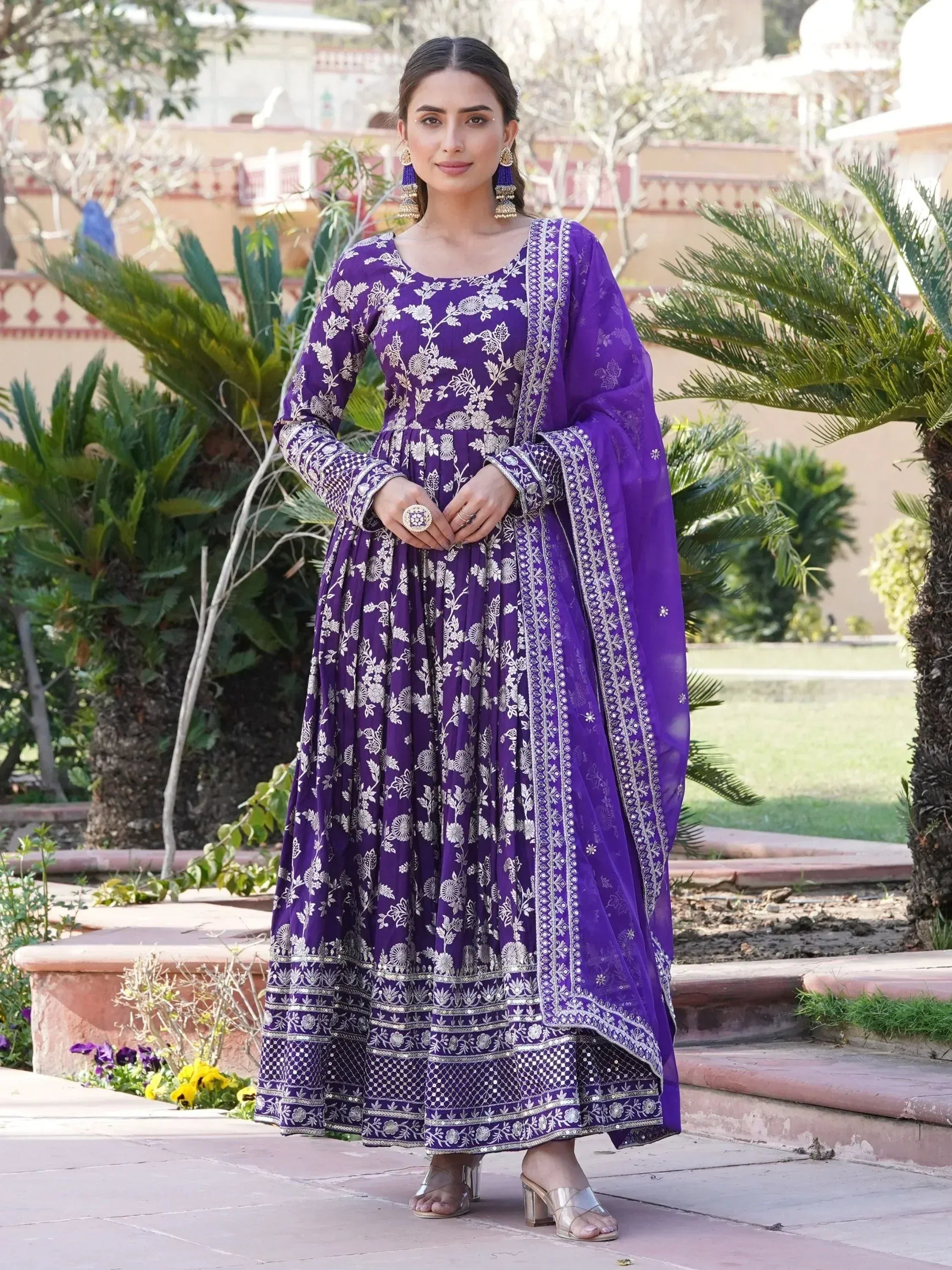 Woman in purple embroidered Anarkali dress with dupatta, outdoor garden setting