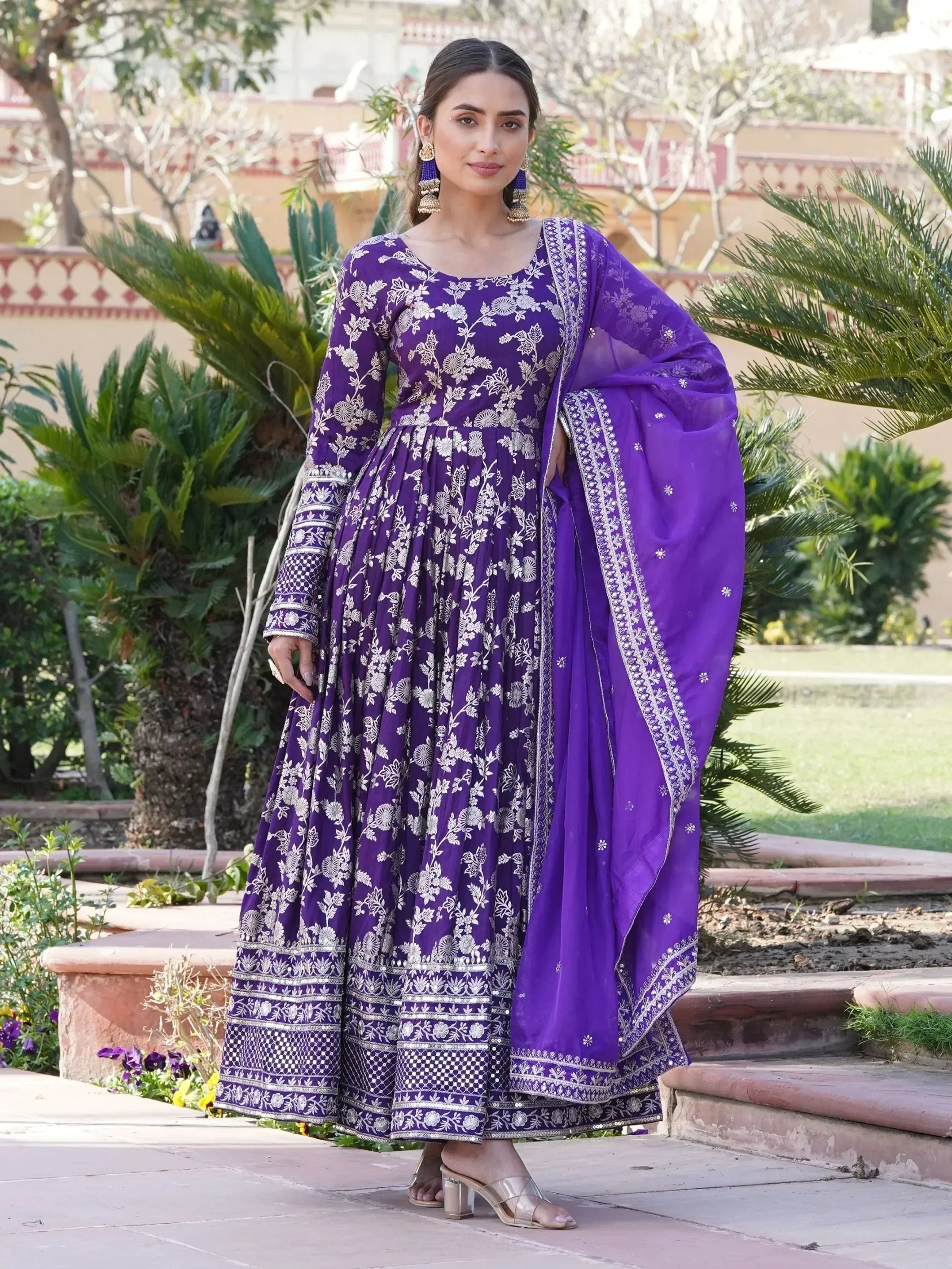 Woman in a purple embroidered ethnic gown with dupatta, traditional Indian attire outdoors