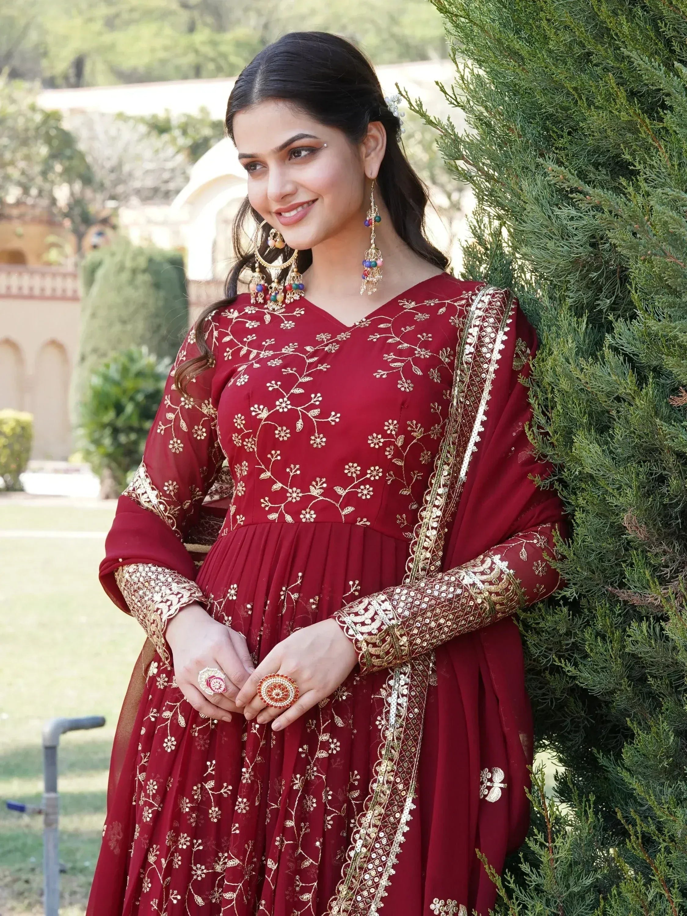 Maroon ethnic gown with gold floral embroidery, perfect for Indian weddings or festive occasions