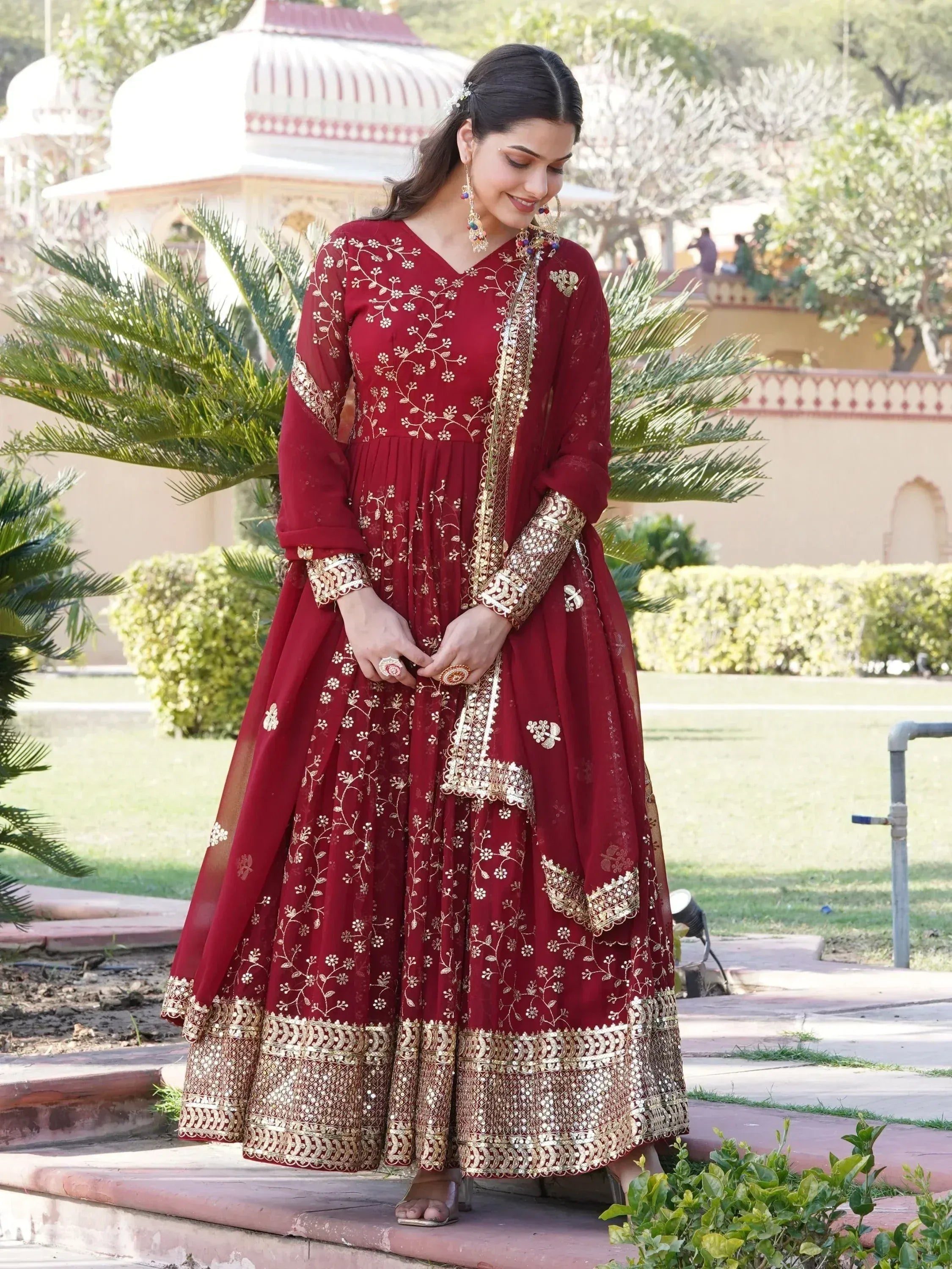 Elegant maroon ethnic gown with gold embroidery, perfect for Indian celebrations and festive occasions.