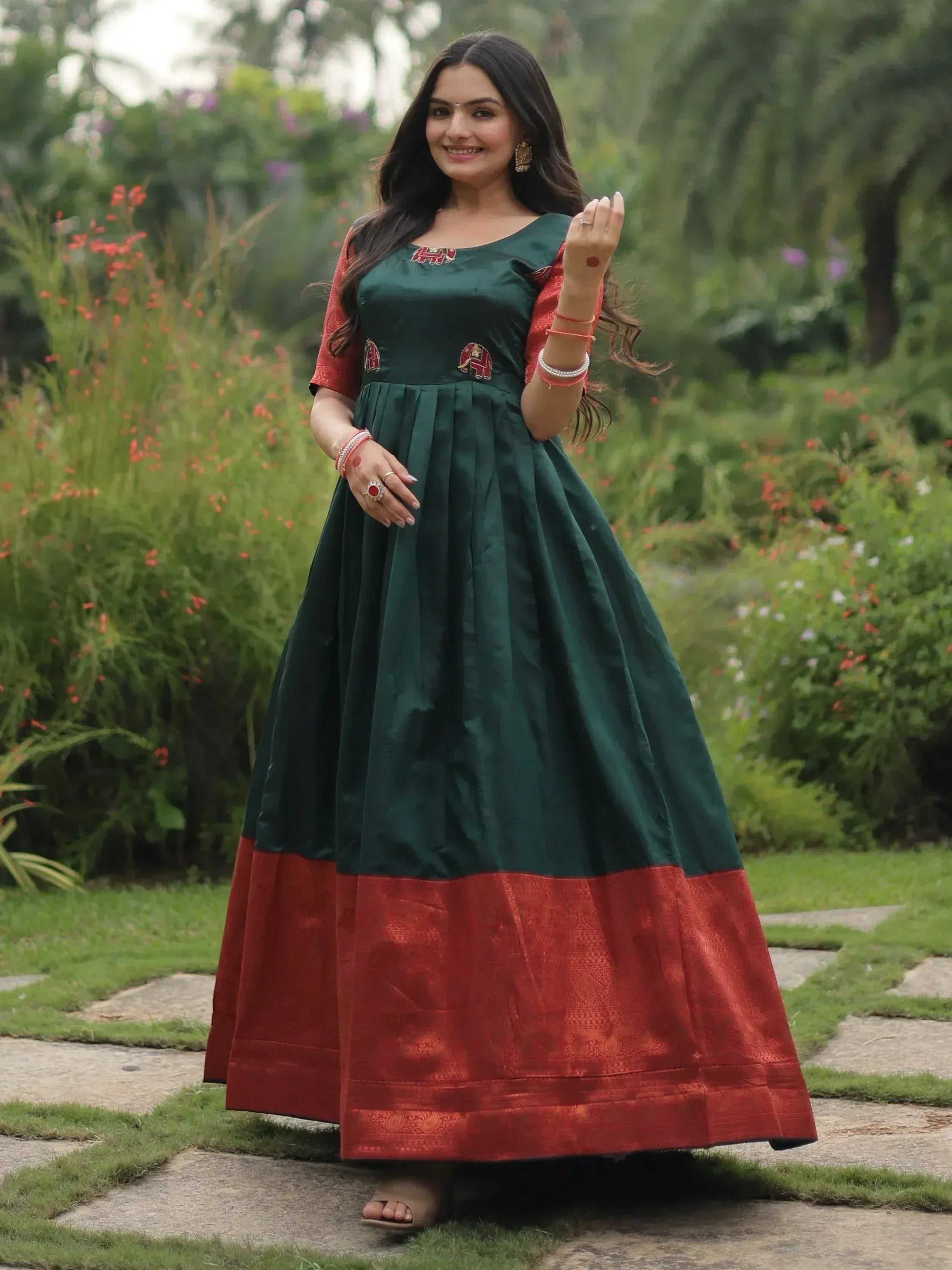 Woman in green and red ethnic gown with elephant embroidery, perfect for Indian occasions