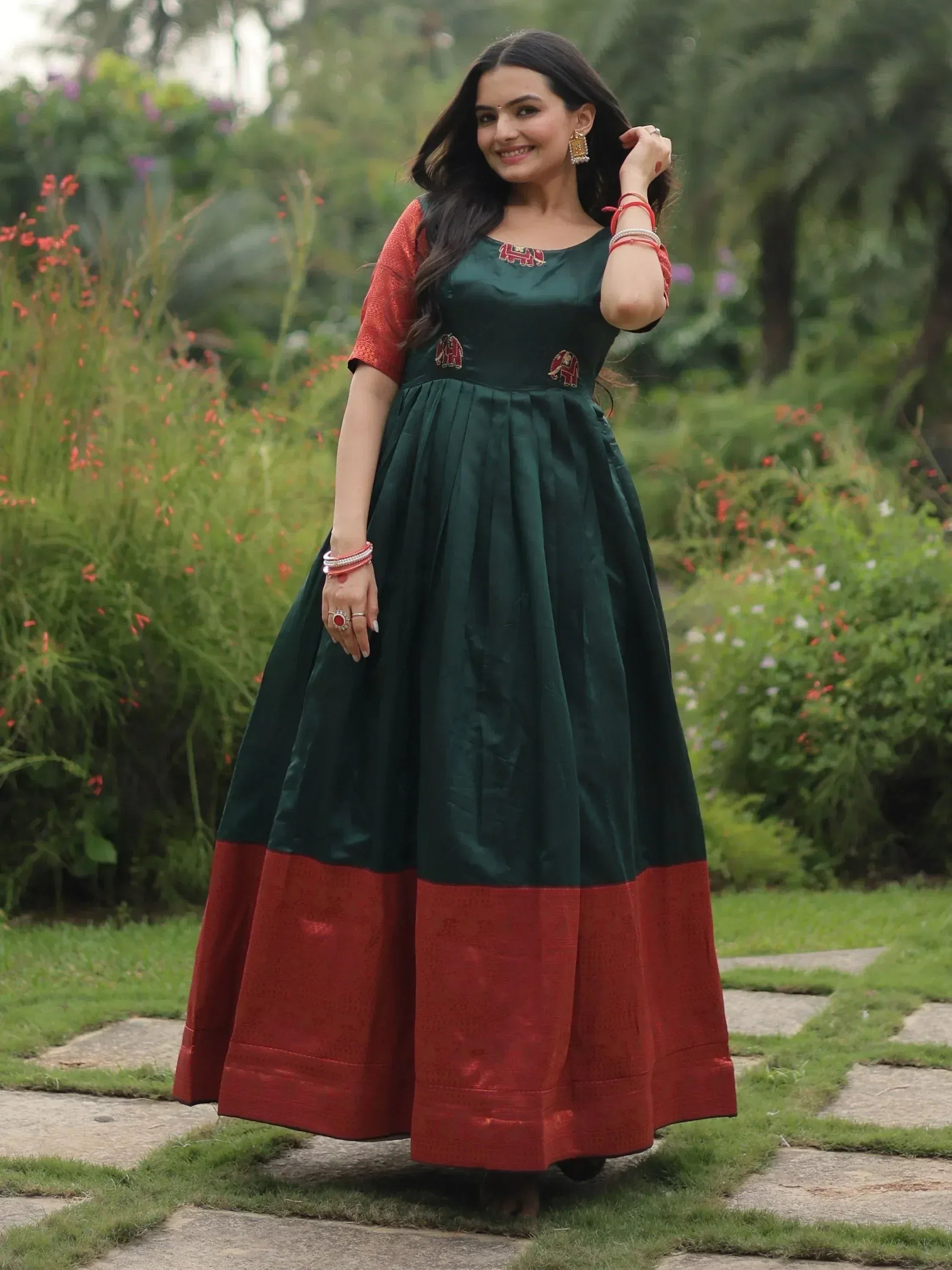 Woman in green and red ethnic gown with elephant embroidery, perfect for Indian festive occasions