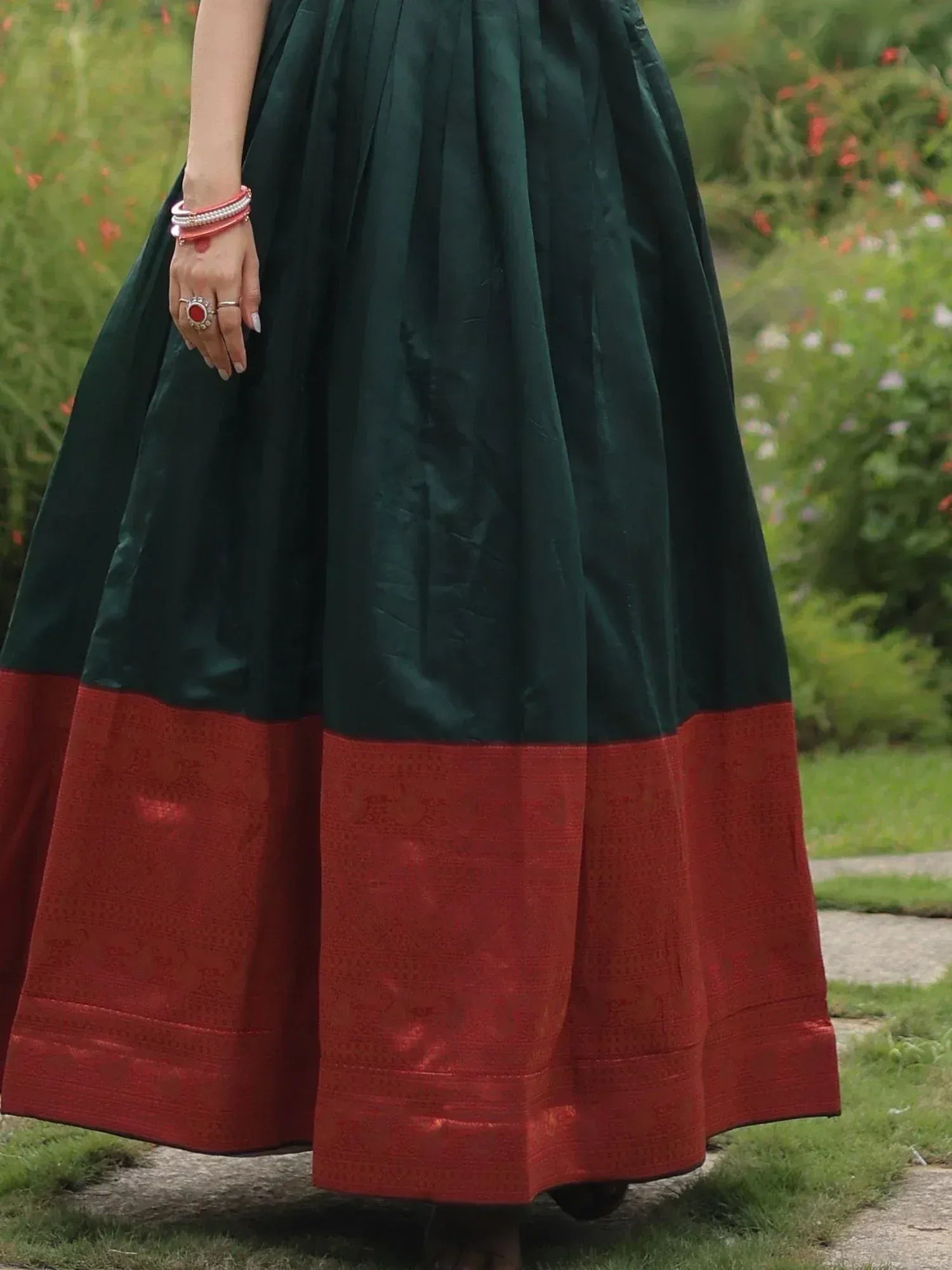 Emerald green and maroon ethnic skirt with woven border, styled with traditional bangles and ring for festive occasions