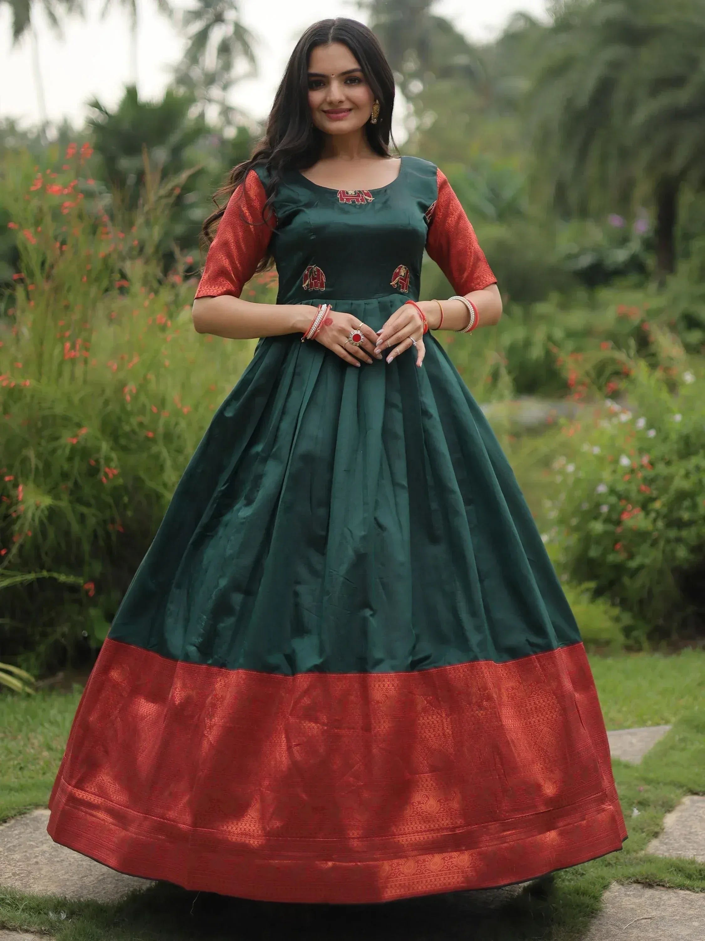 Green and red ethnic gown with elephant embroidery, perfect for Indian festivals and occasions.