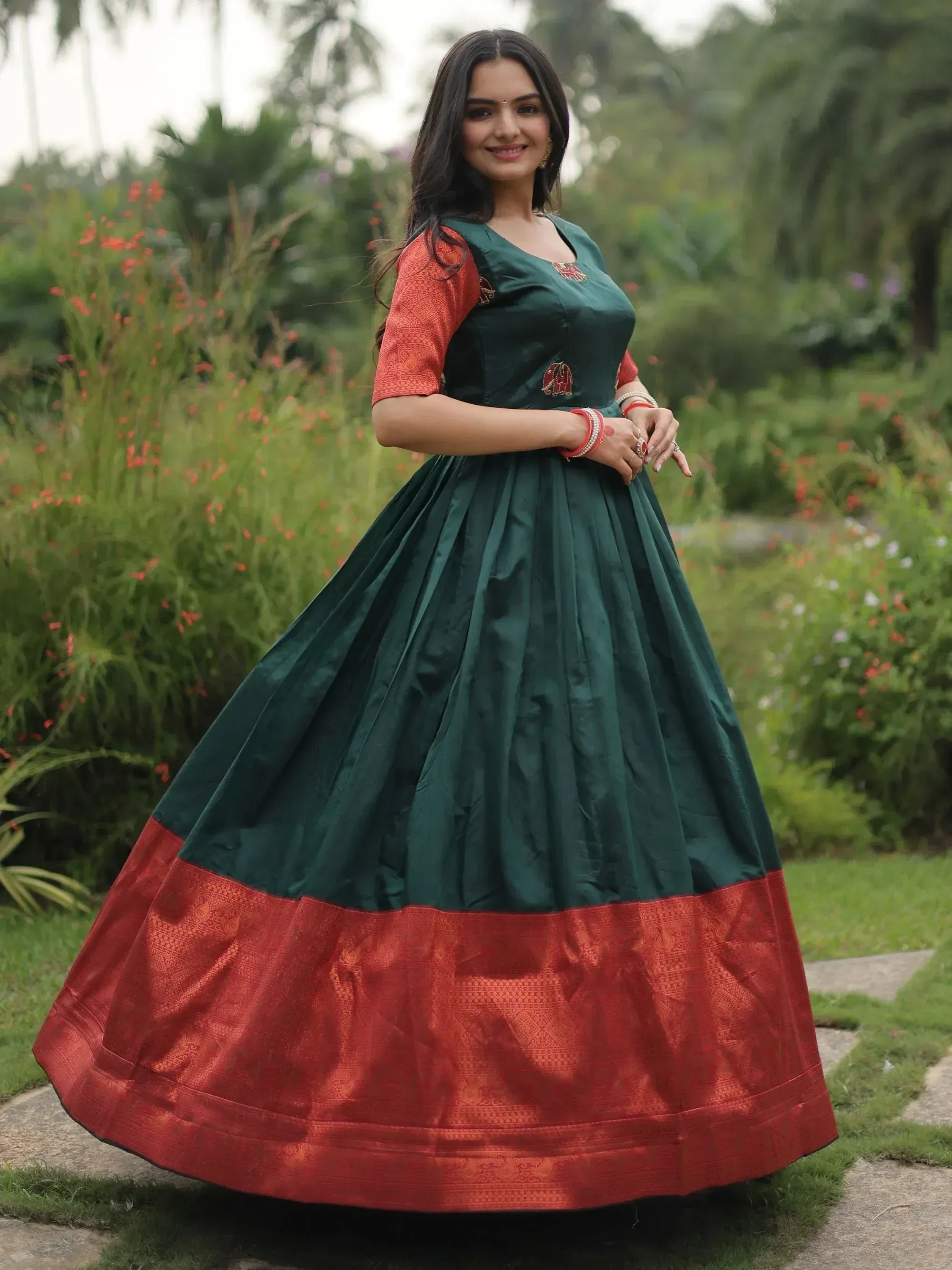 Green and red ethnic gown with elephant embroidery, perfect for Indian festivals and occasions.