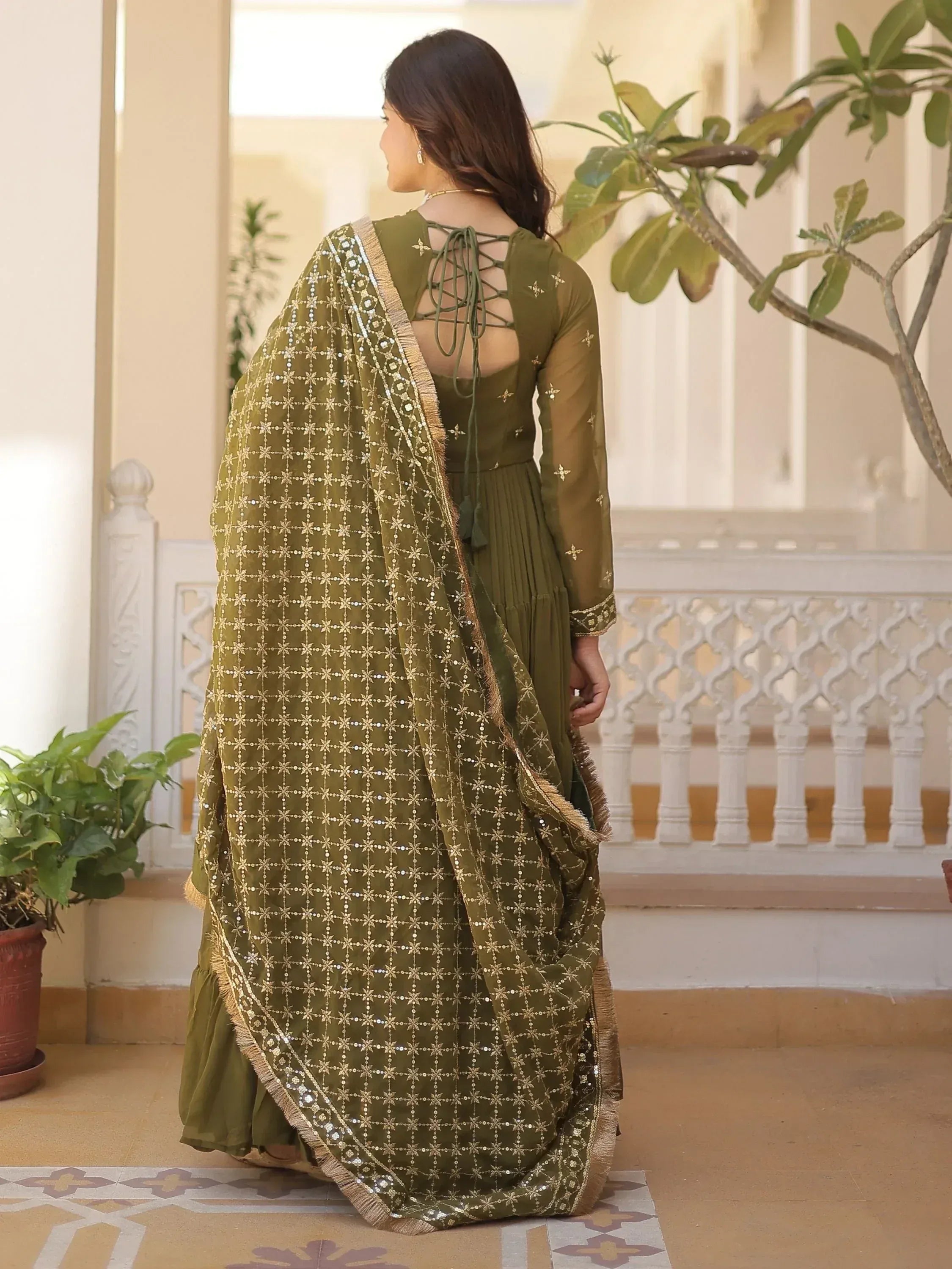 Olive green ethnic gown with gold star embroidery and lace-up back, paired with matching dupatta for Indian wear.
