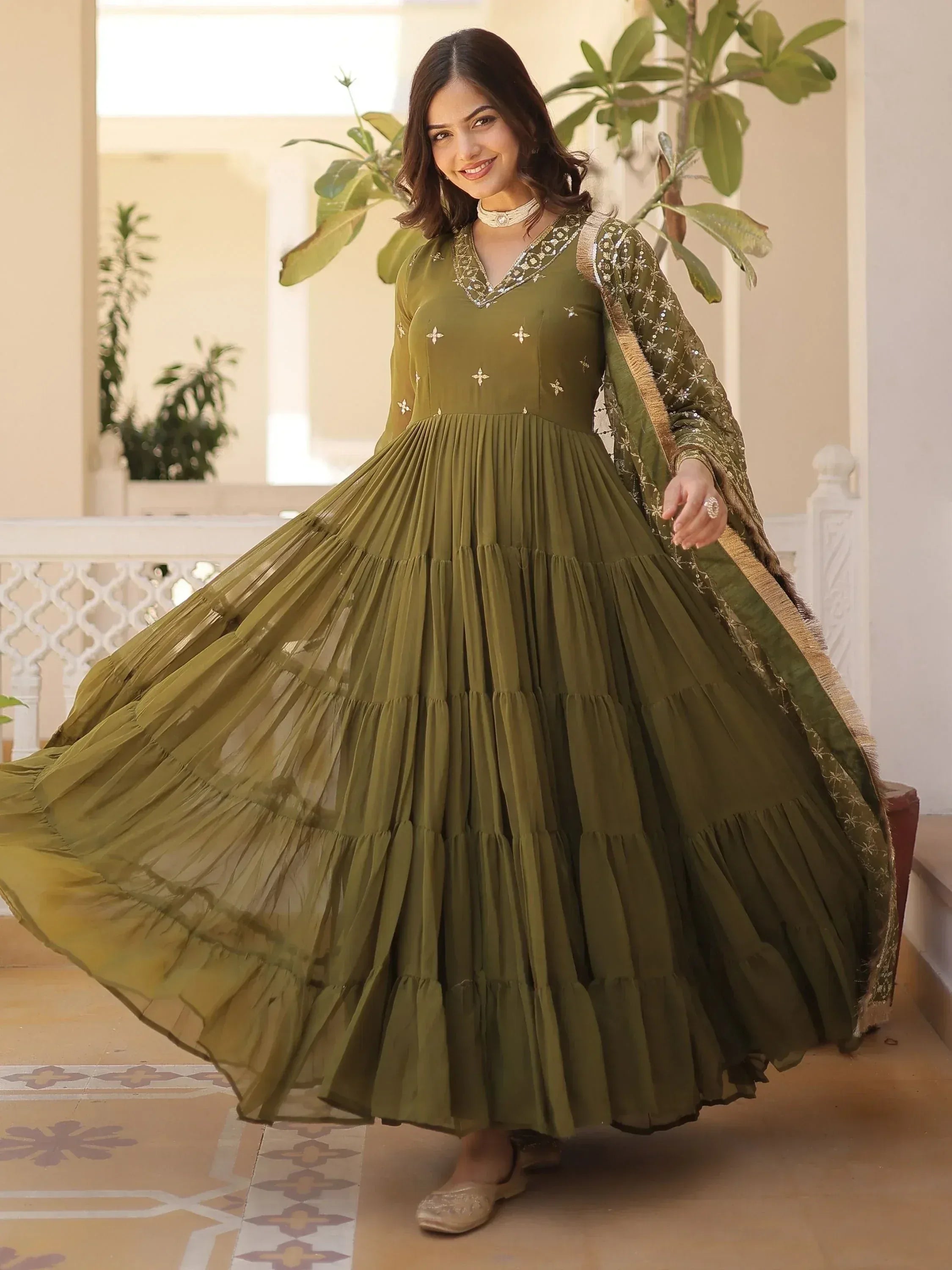 Olive green ethnic gown with pleated skirt and gold embroidery, perfect for Indian festive occasions.