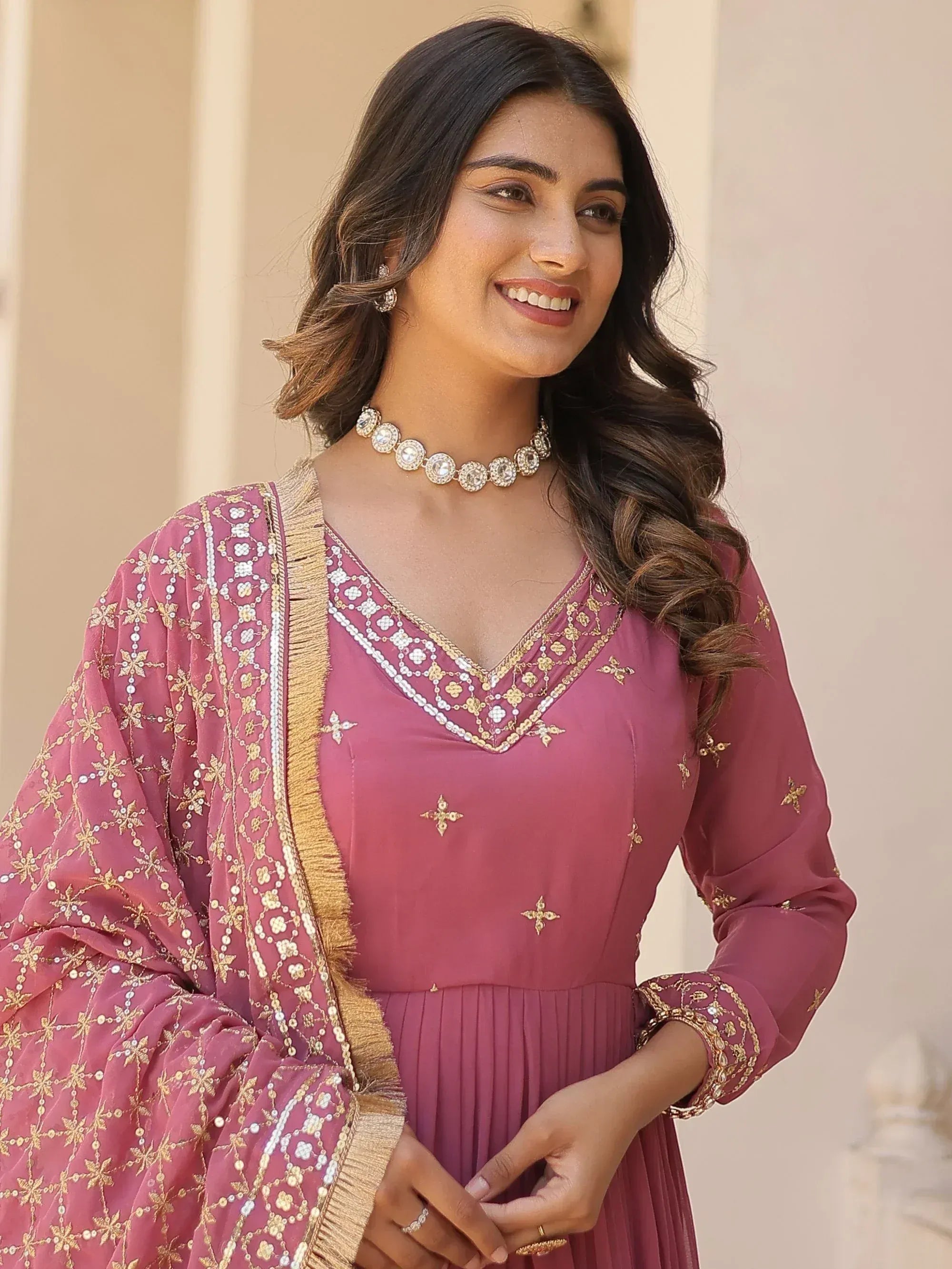 Pink embroidered ethnic gown with gold detailing and matching dupatta, perfect for Indian occasions
