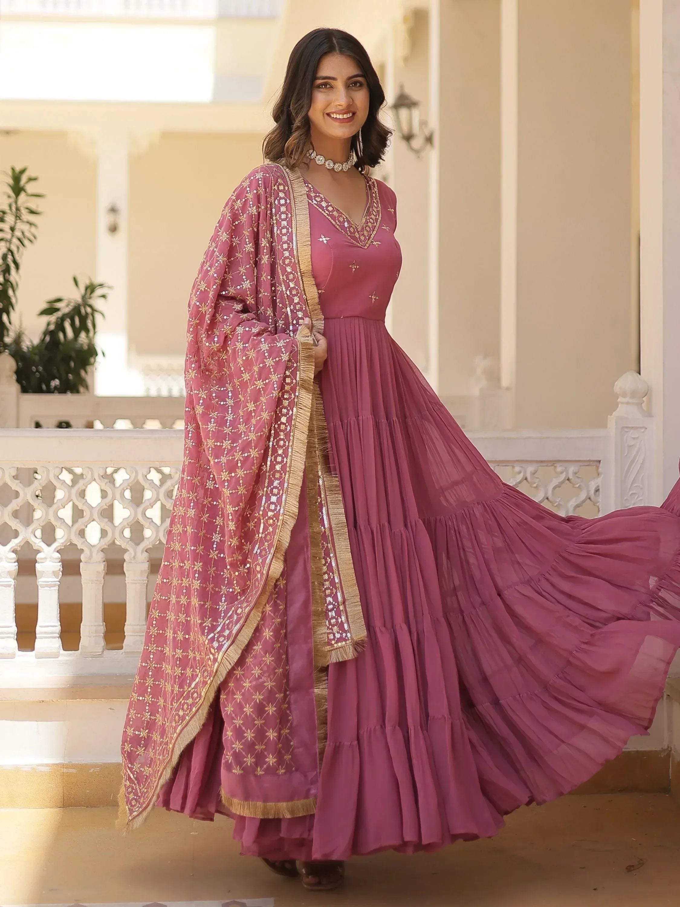 Pink ethnic gown with gold embroidery and dupatta, perfect for Indian weddings or festive occasions