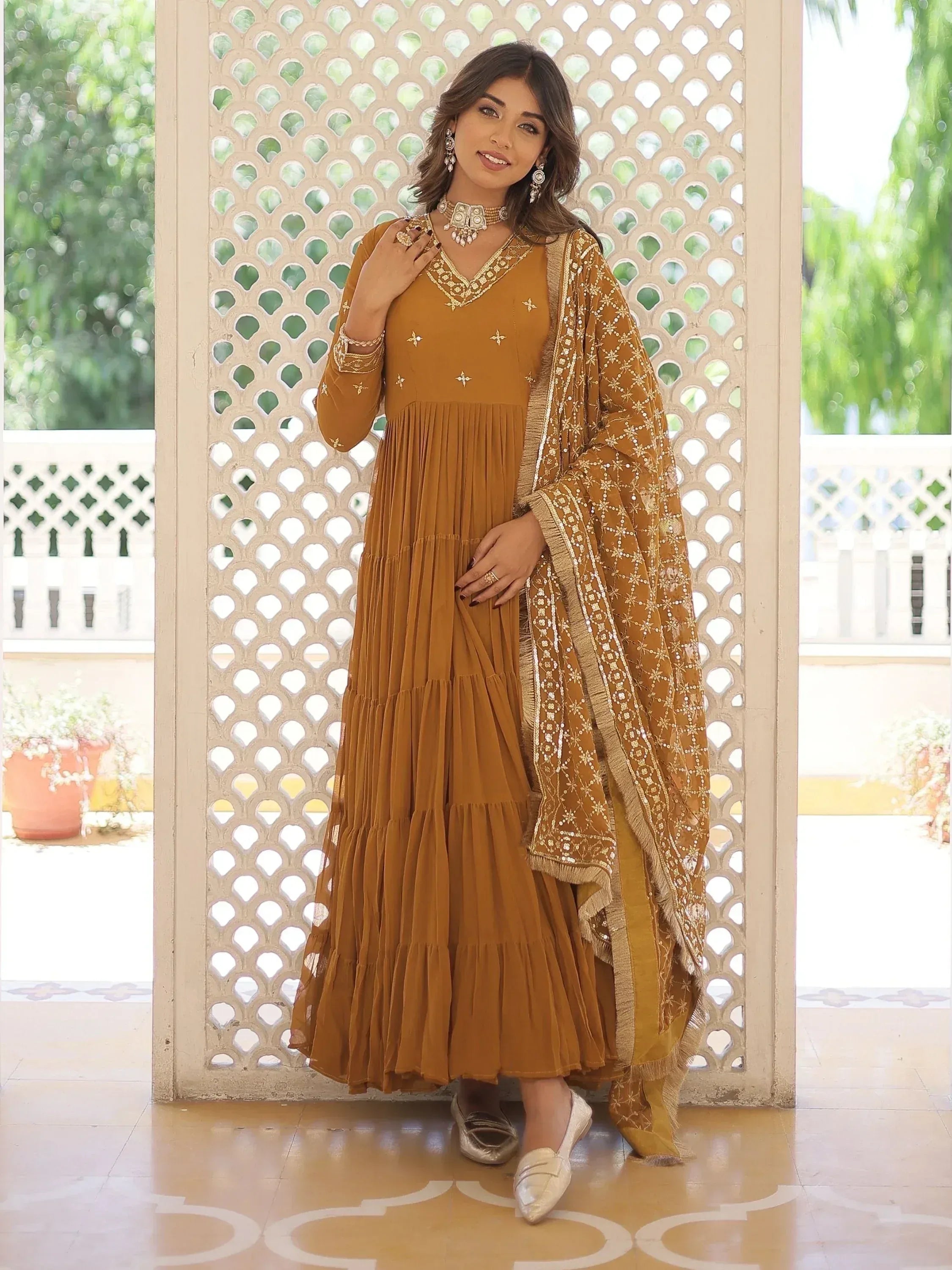 Mustard ethnic gown with gold embroidery and pleated skirt, paired with matching dupatta for Indian wear