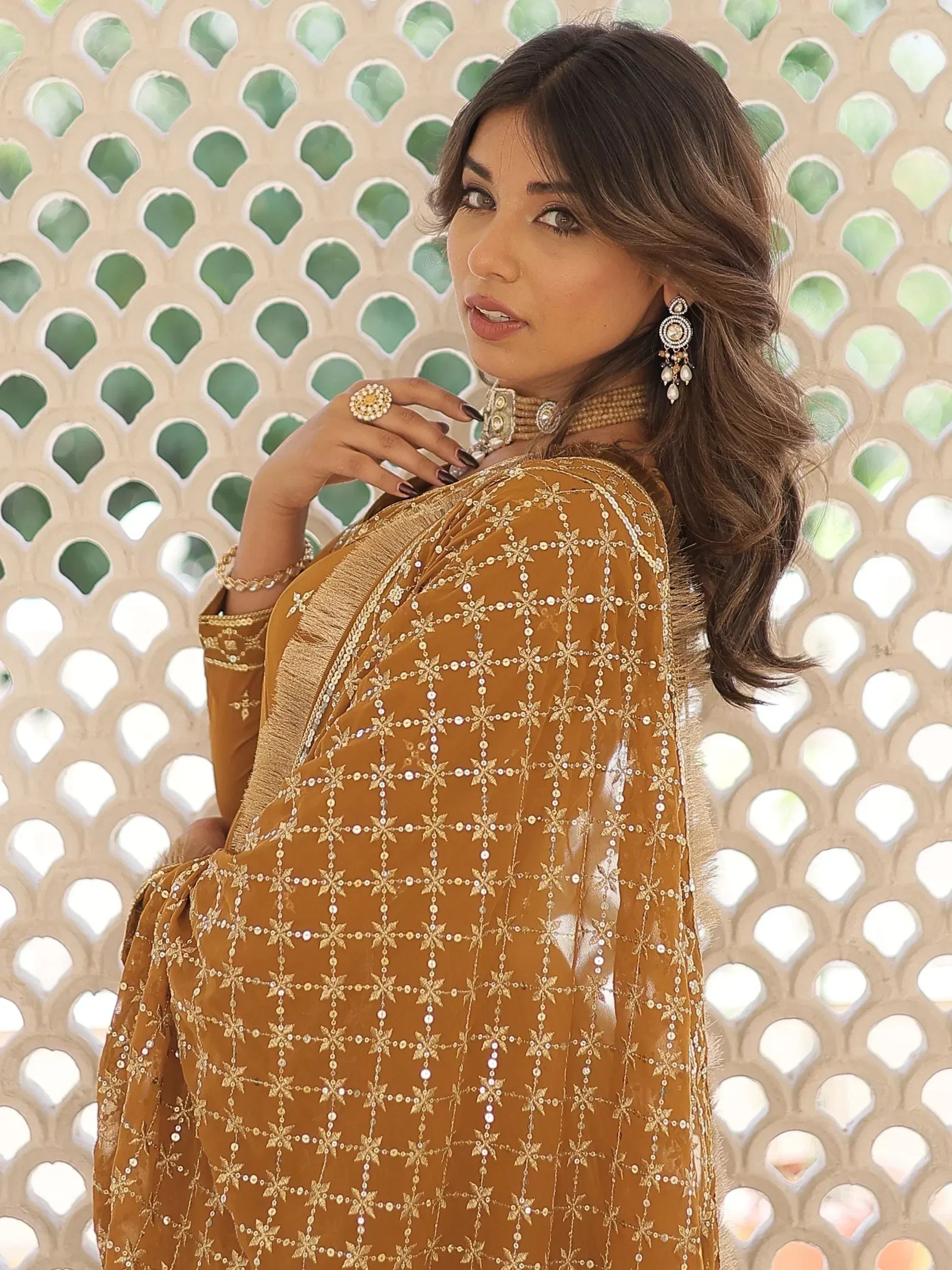 Woman in mustard velvet salwar kameez with gold embroidery and mirror work, traditional Indian ethnic wear