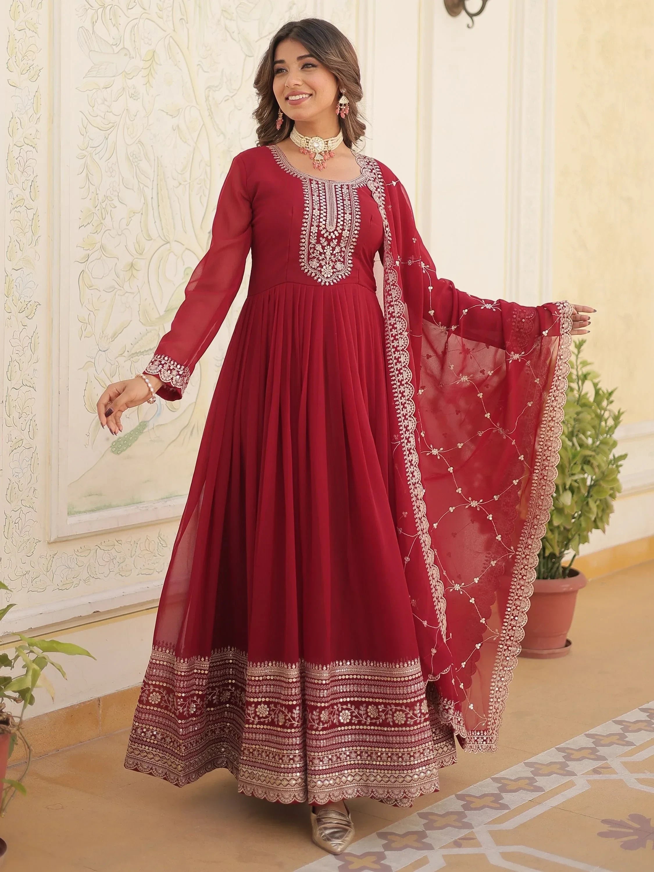 Woman in maroon embroidered Anarkali gown with dupatta, traditional Indian ethnic wear