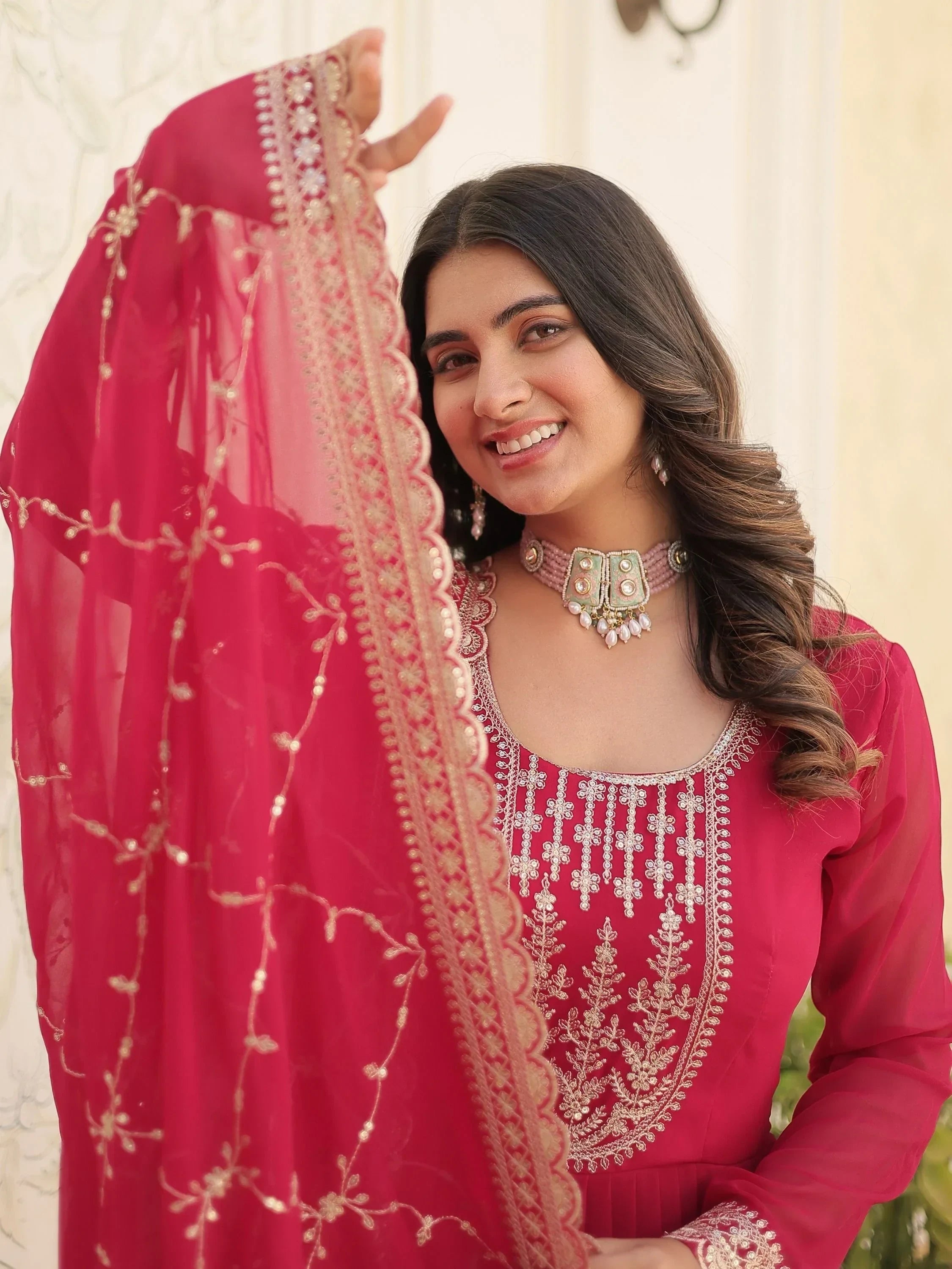 Woman wearing pink embroidered salwar kameez with matching dupatta, traditional Indian attire