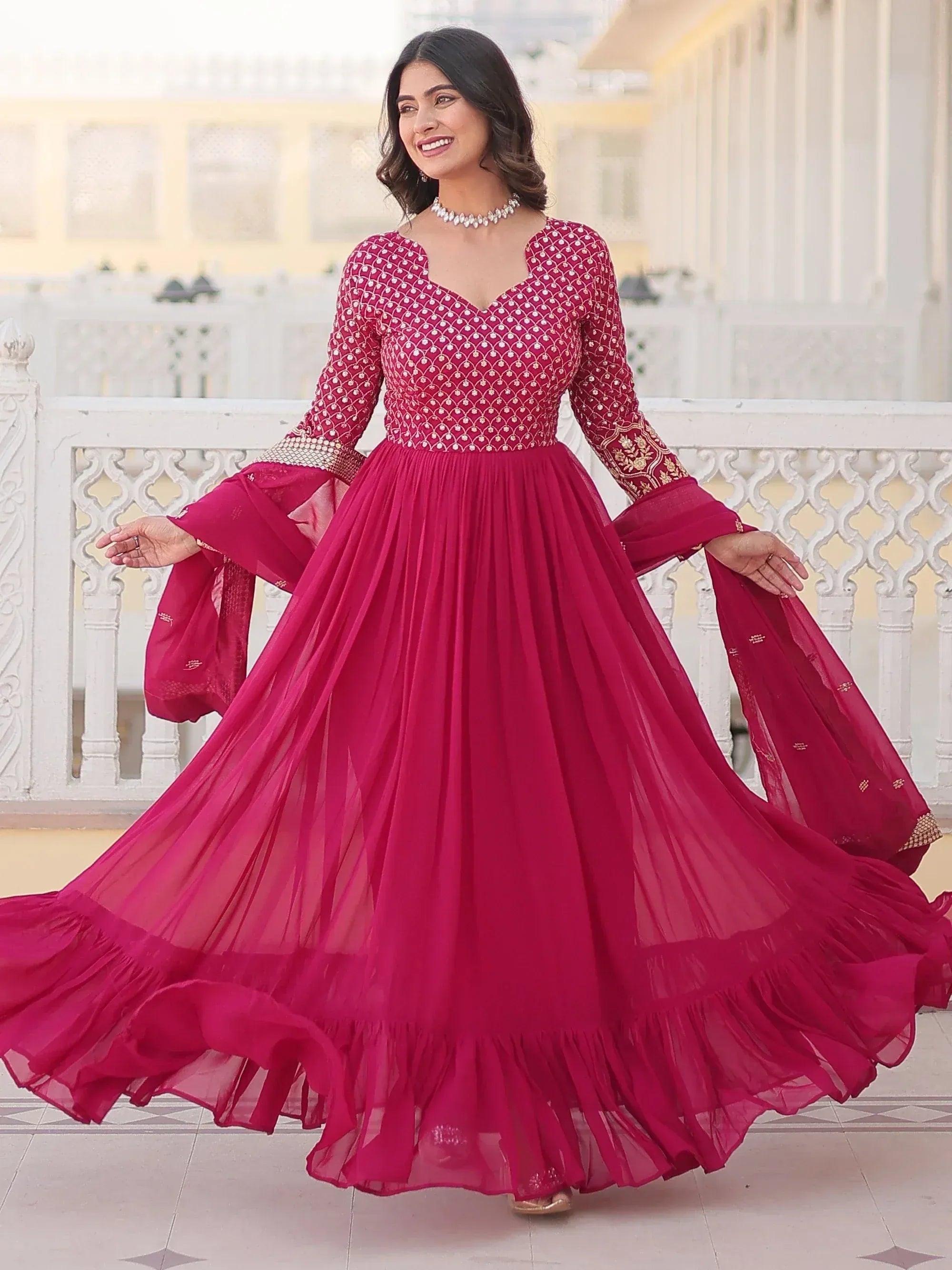 Elegant maroon ethnic gown with intricate embroidery and flared skirt, perfect for Indian celebrations