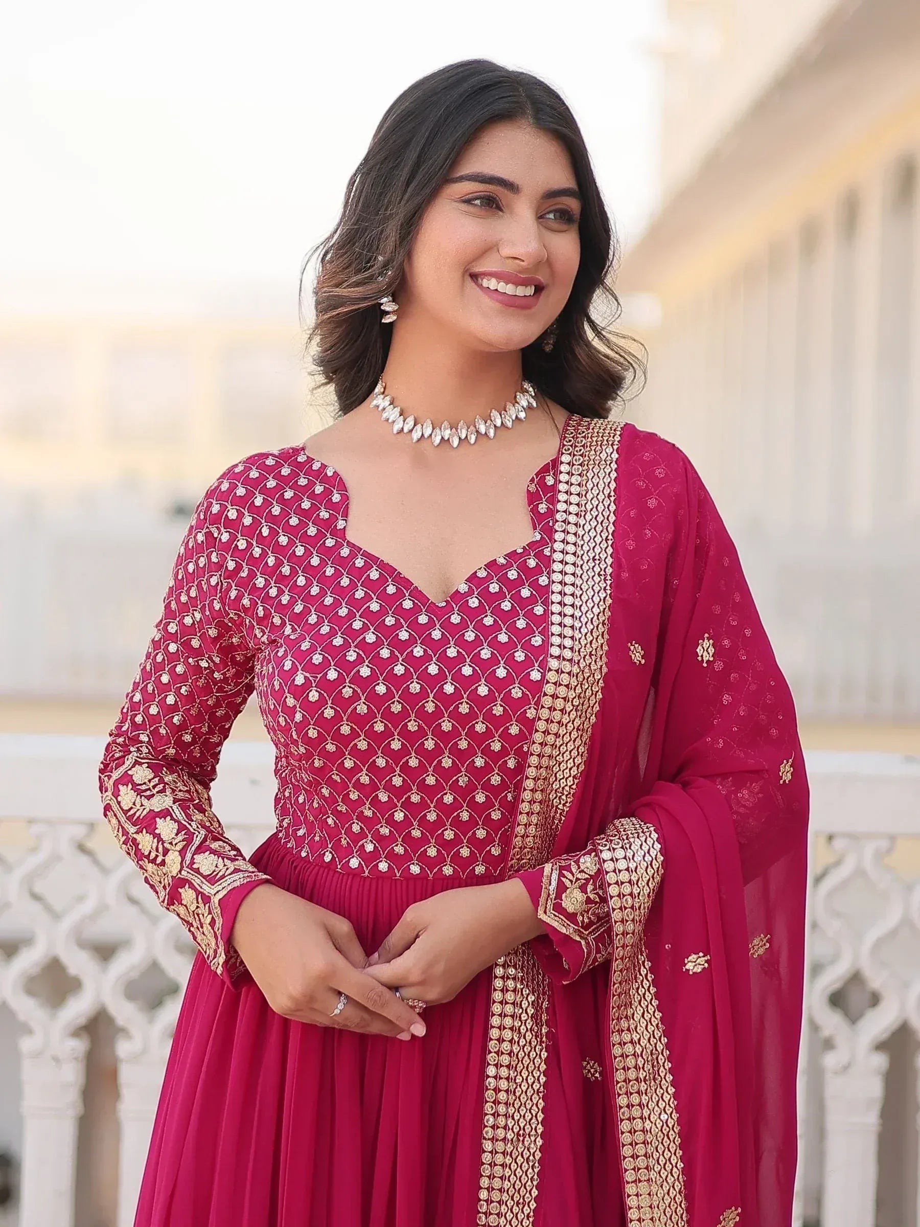 Elegant maroon ethnic gown with gold embroidery, perfect for Indian occasions and celebrations.