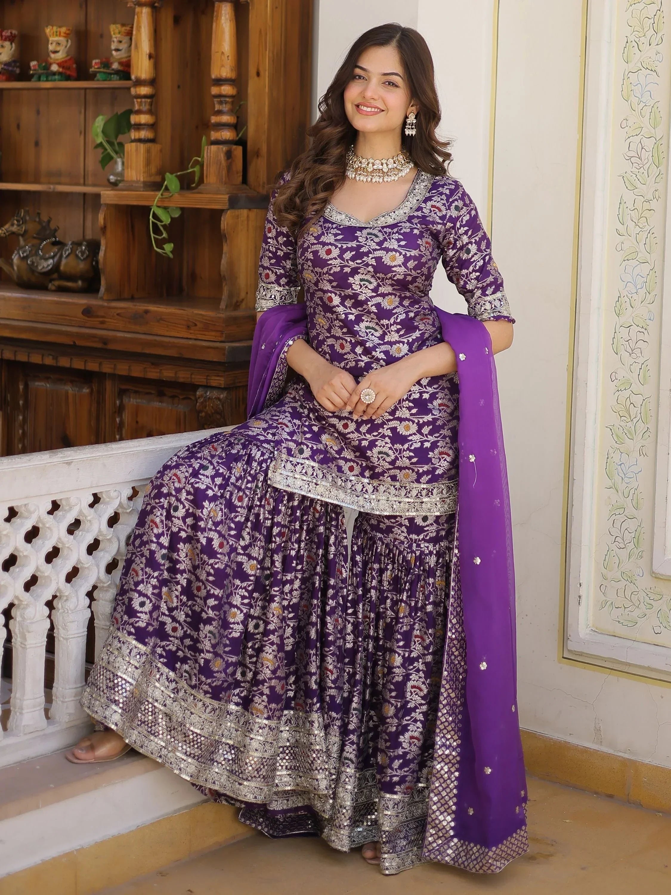 Woman wearing purple floral embroidered lehenga choli with dupatta, traditional Indian attire