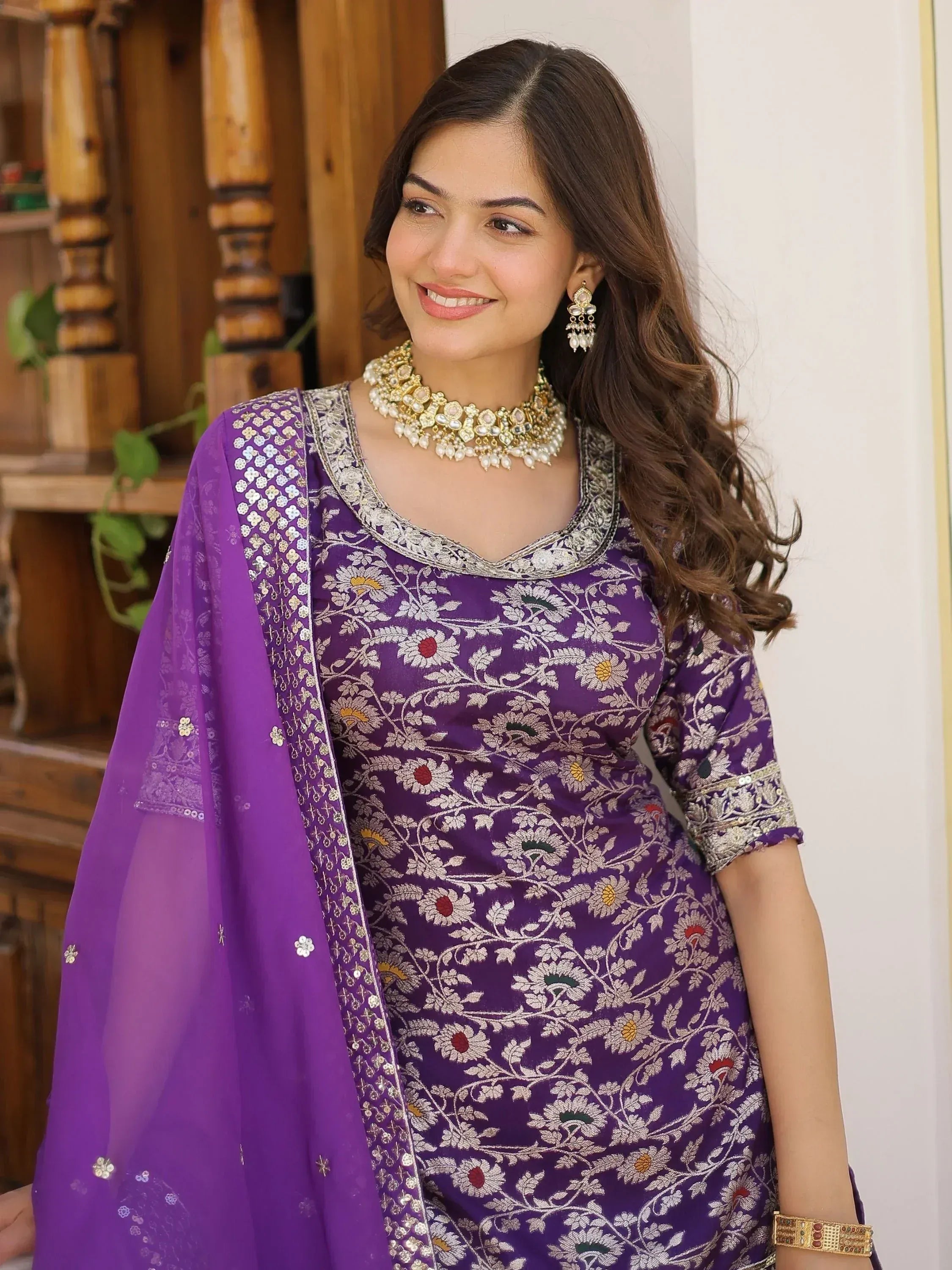 Purple floral embroidered salwar kameez with matching dupatta and traditional jewelry