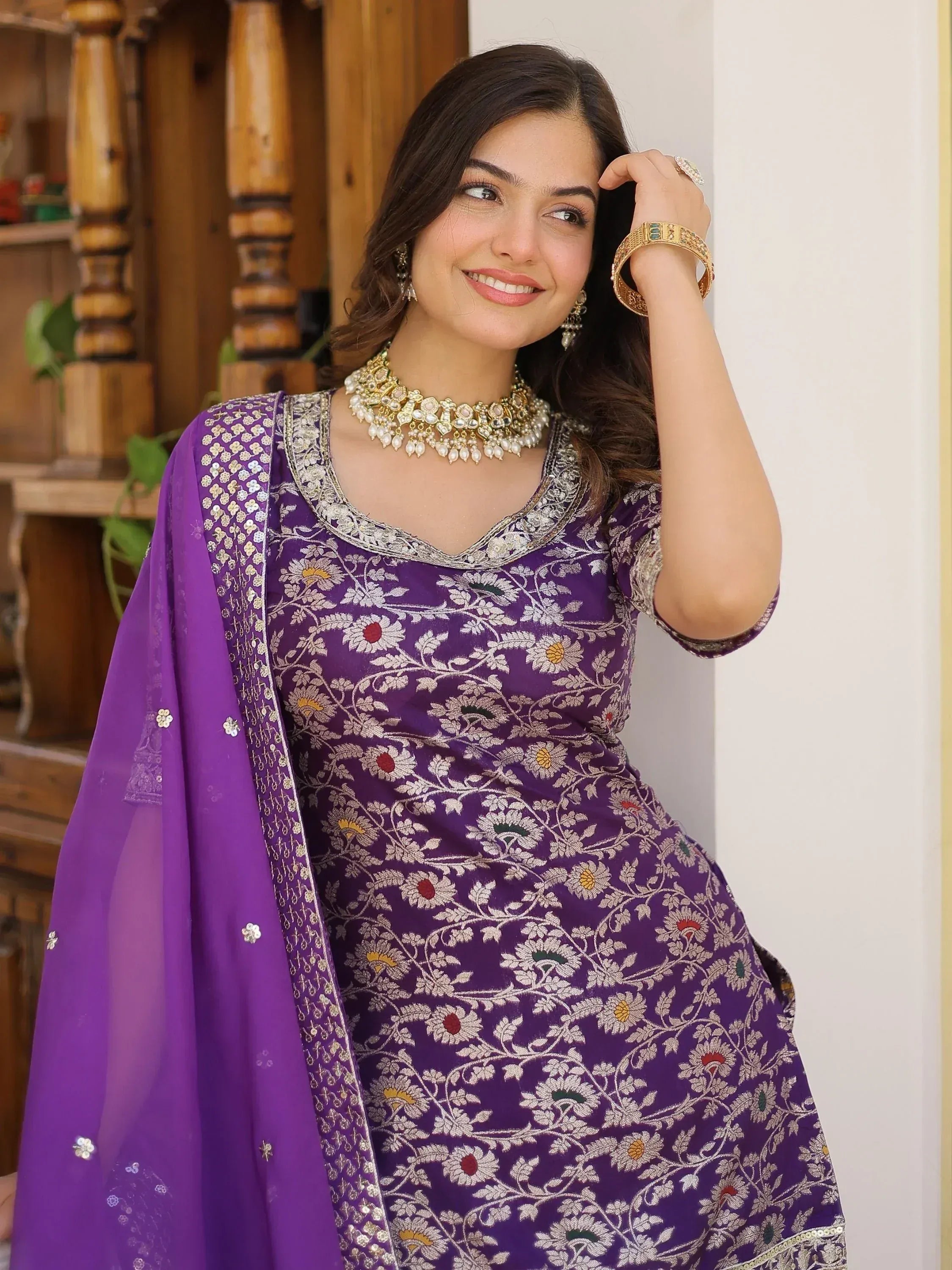 Purple floral embroidered Indian ethnic gown with matching dupatta and traditional jewelry