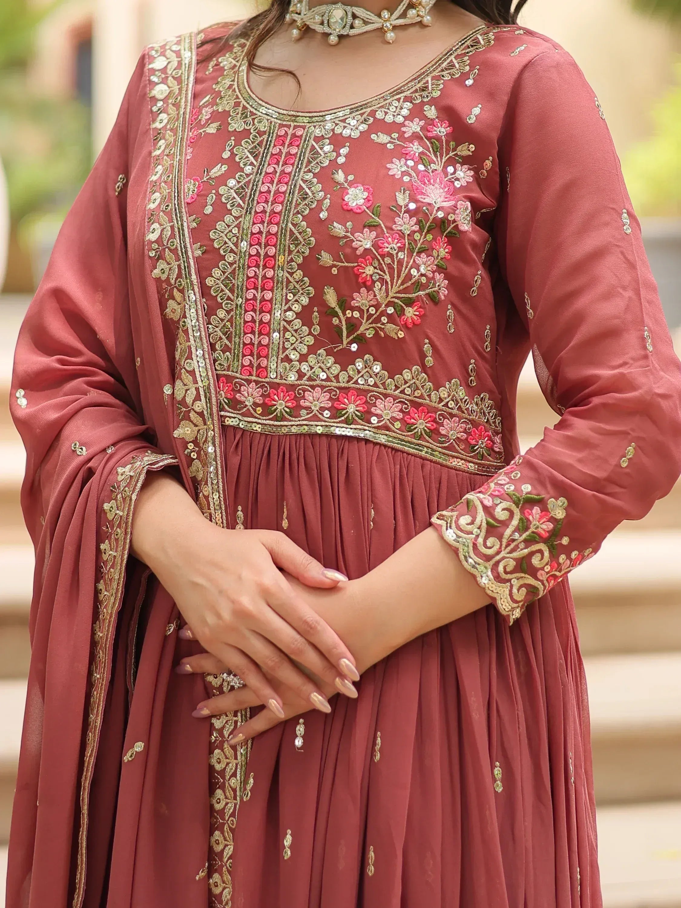Dusty rose ethnic gown with floral embroidery and gold detailing, perfect for Indian festive occasions
