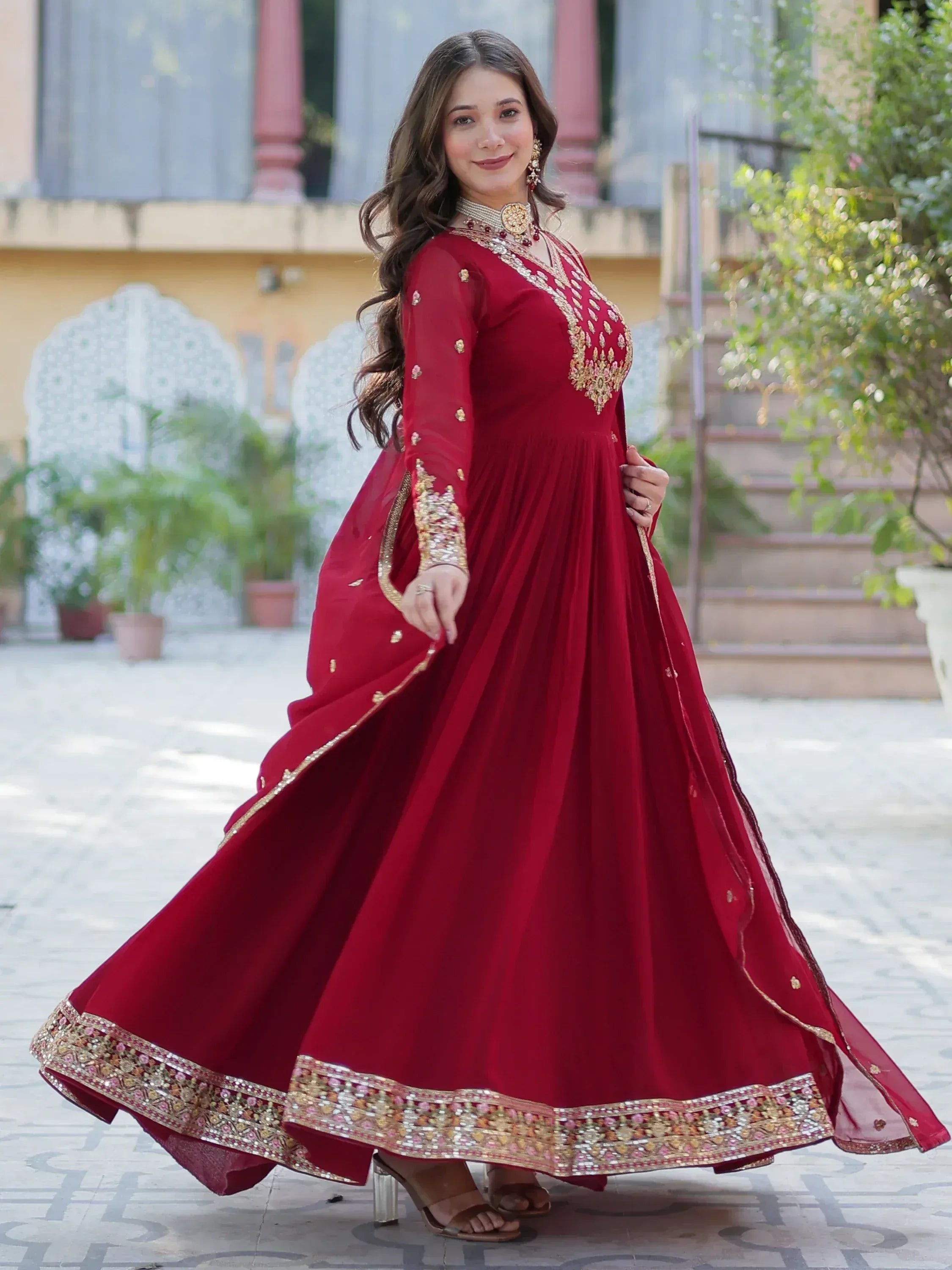 Elegant maroon ethnic gown with gold embroidery, perfect for Indian weddings and festive occasions.