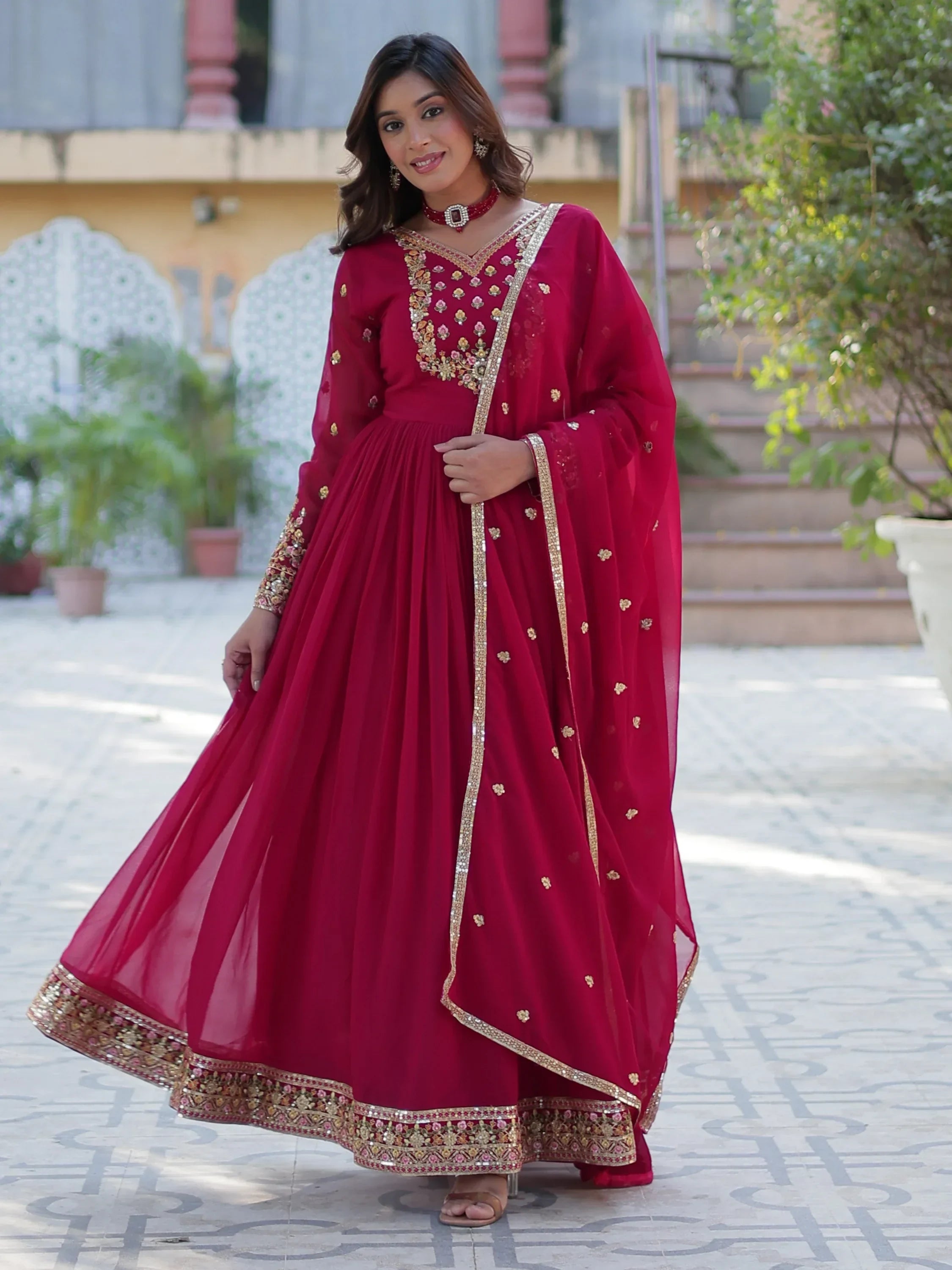 Woman wearing a pink embroidered ethnic gown with dupatta, traditional Indian attire